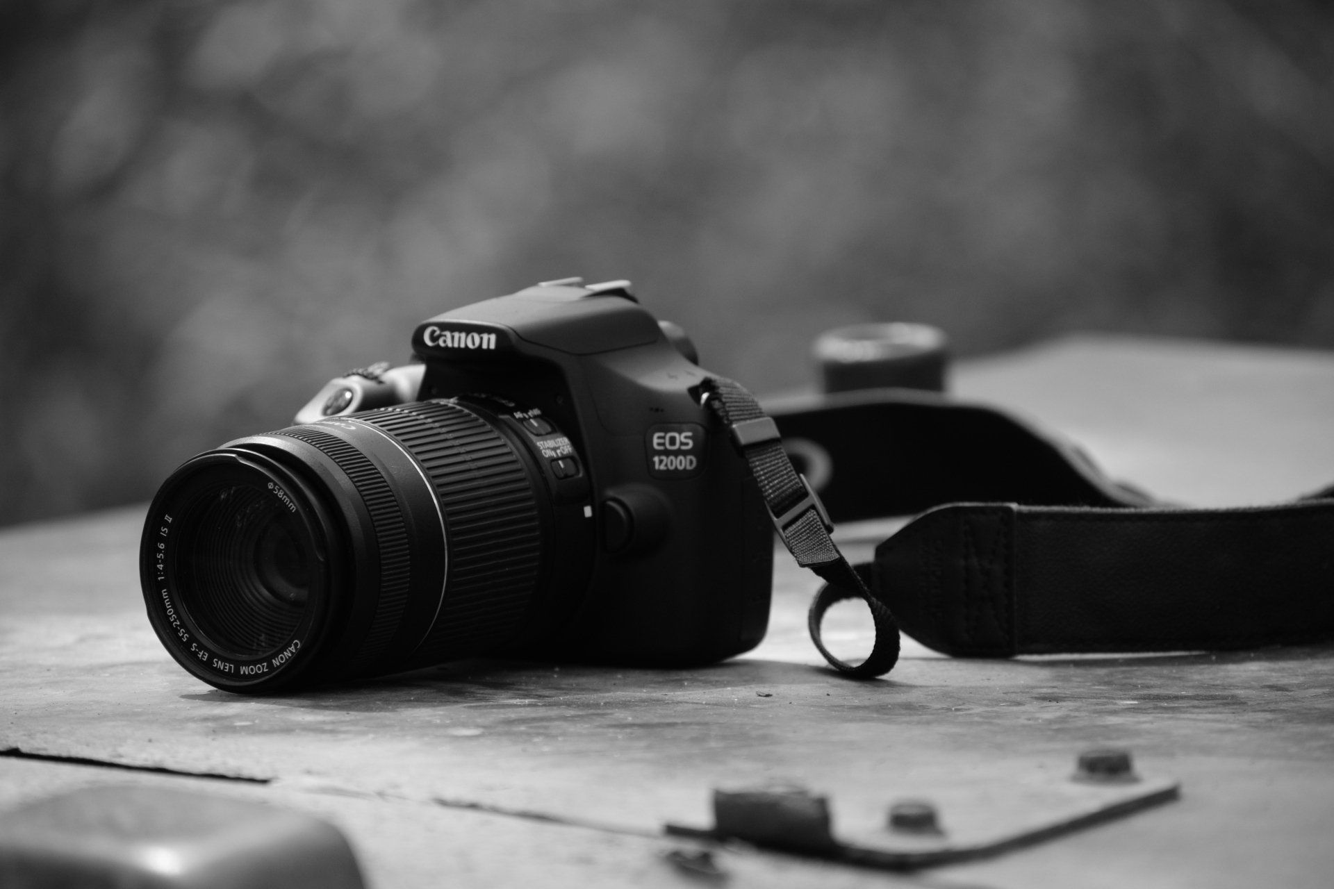 Une photo en noir et blanc d'un appareil photo posé sur une table en bois.