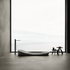 A black and white photo of a bathroom with a large window and a bathtub.