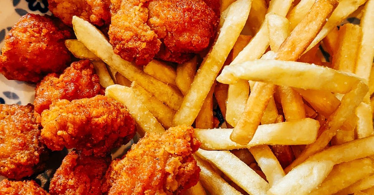 A plate of fried chicken and french fries on a table.