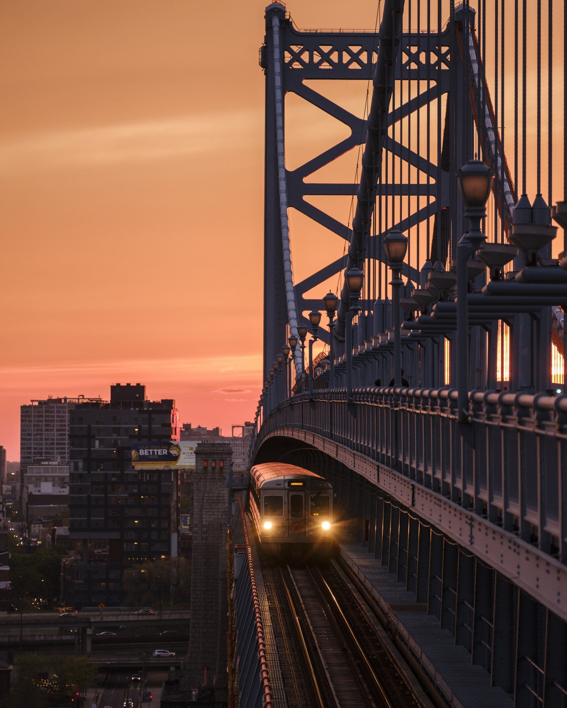 A train is going over a bridge at sunset