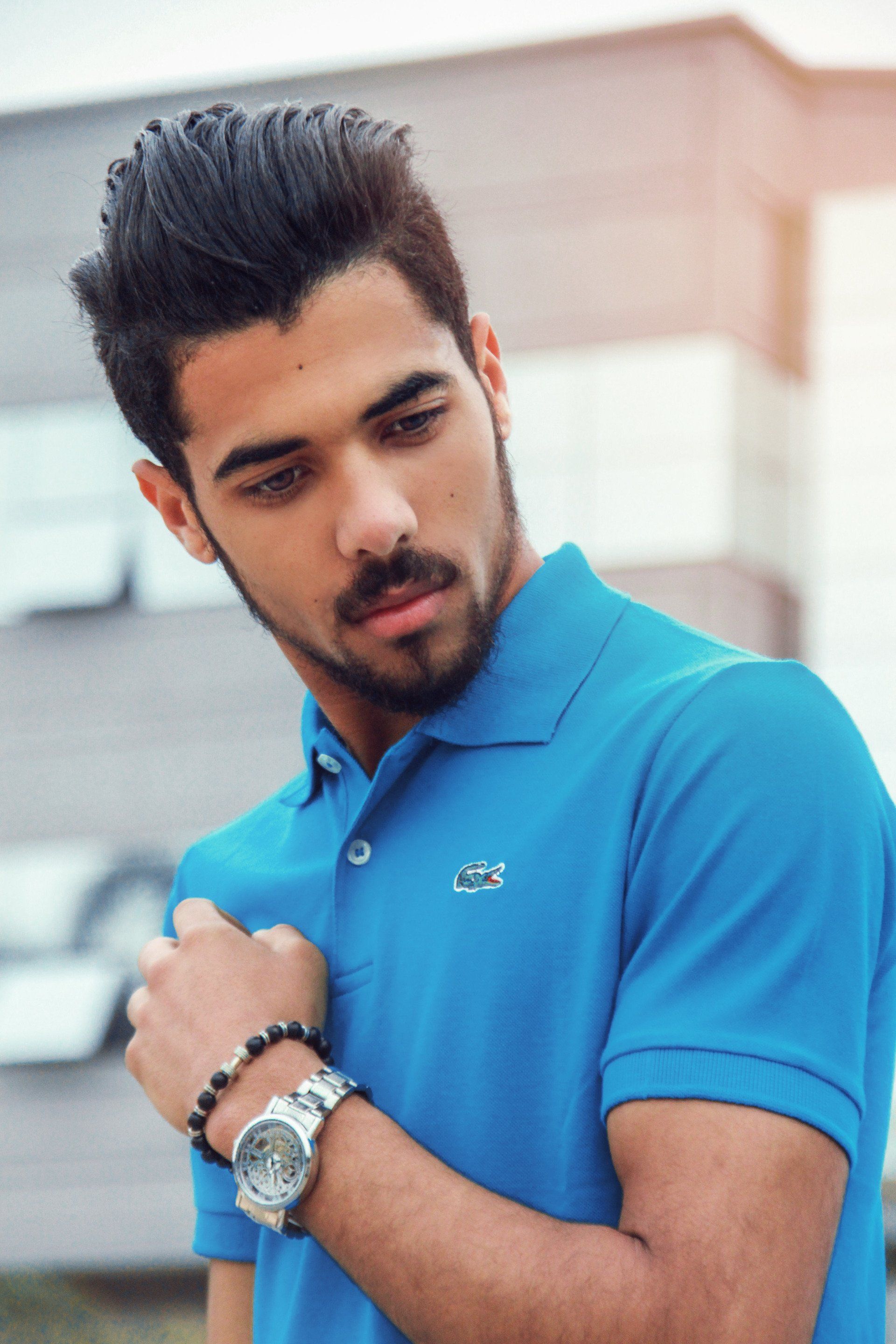 A man wearing a blue polo shirt and a watch
