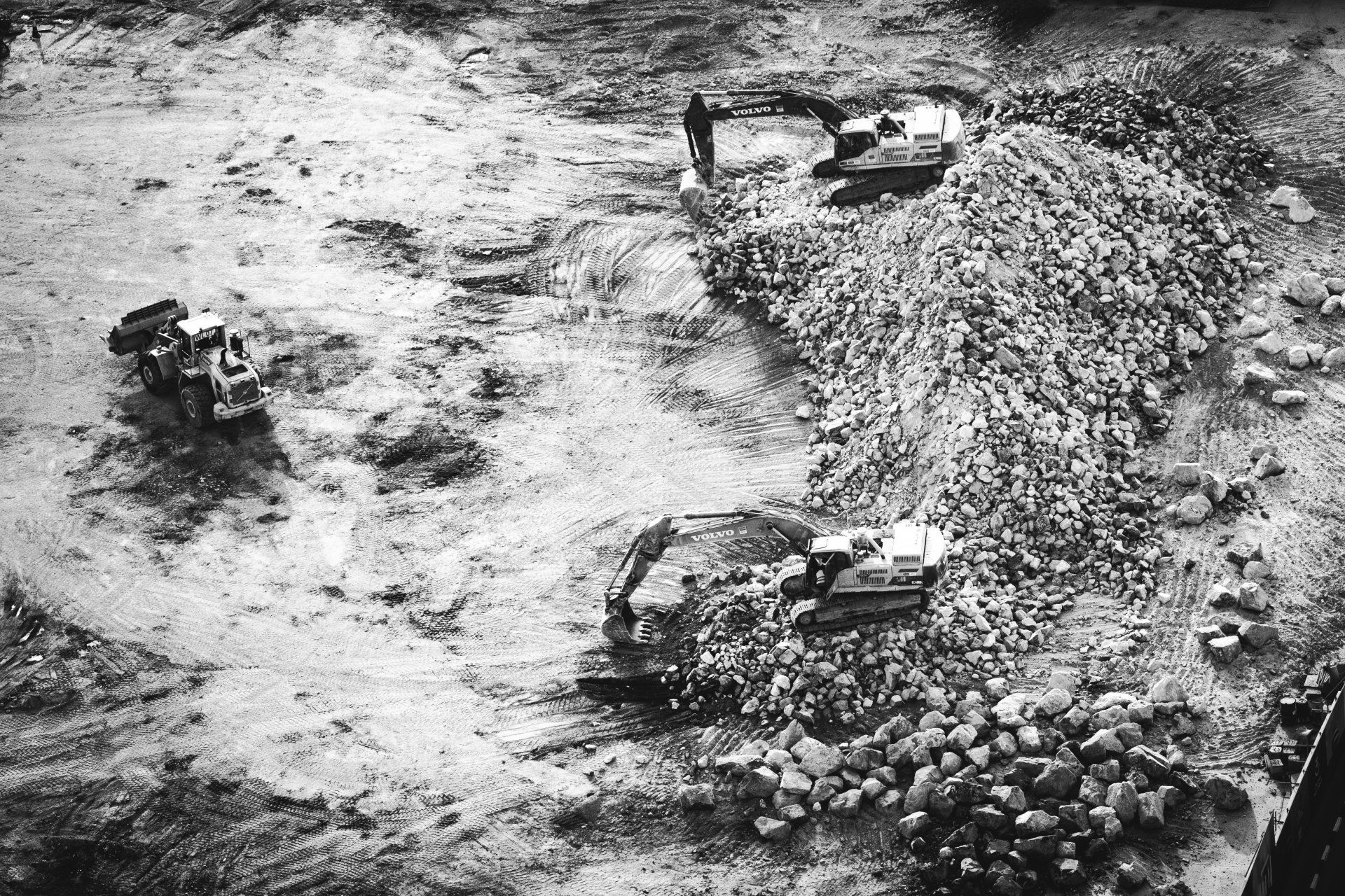 A black and white photo of a group of people working on a large rock quarry in texas