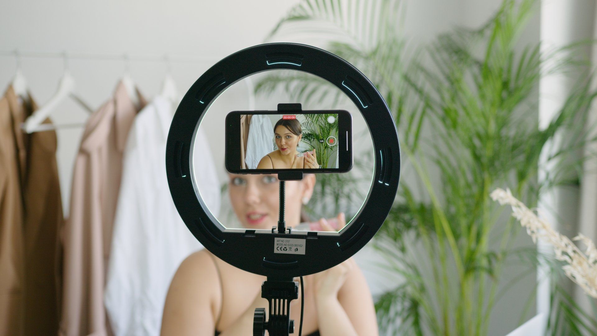 A woman is taking a picture of herself with a ring light.