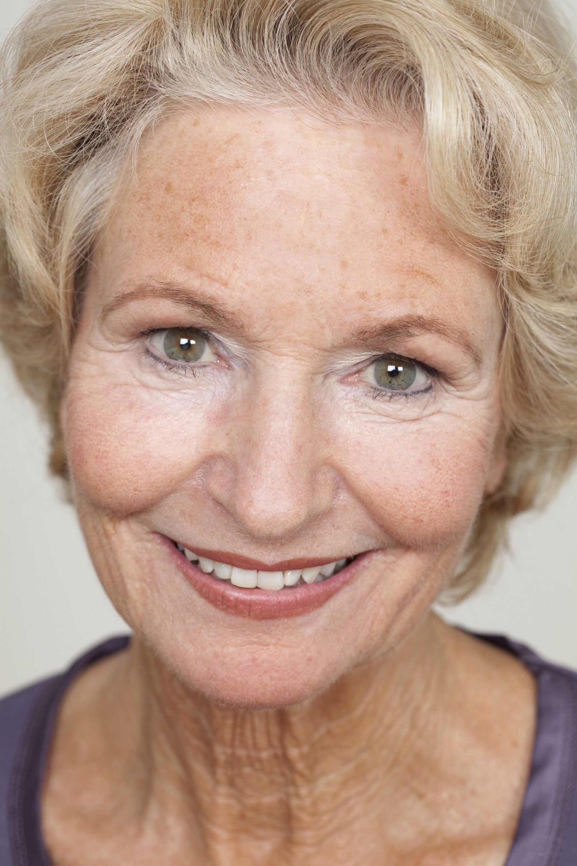 A close up of an older woman 's face smiling.