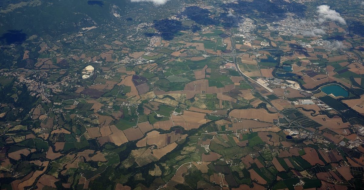 An aerial view of a landscape with lots of fields and trees.