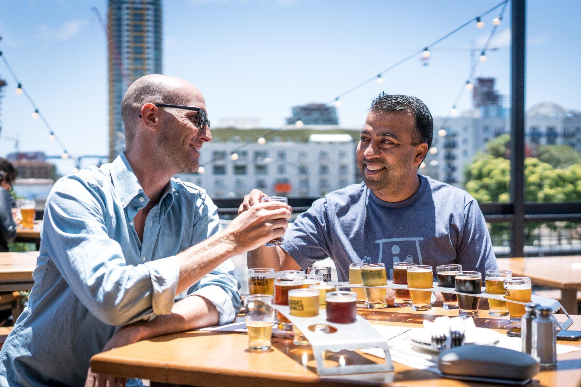 Two men are sitting at a table drinking beer.