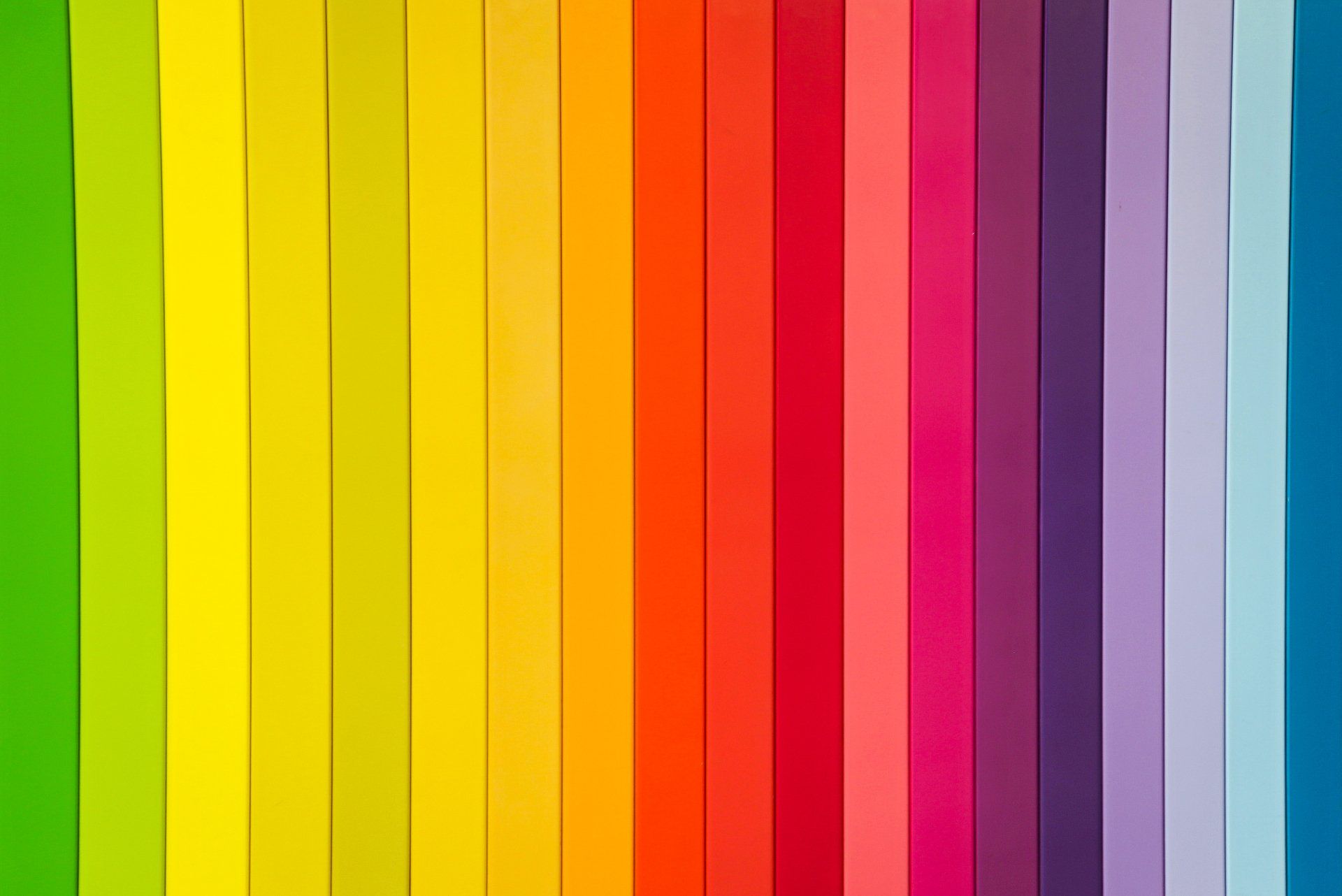 A close up of a rainbow of colored strips lined up in a row.