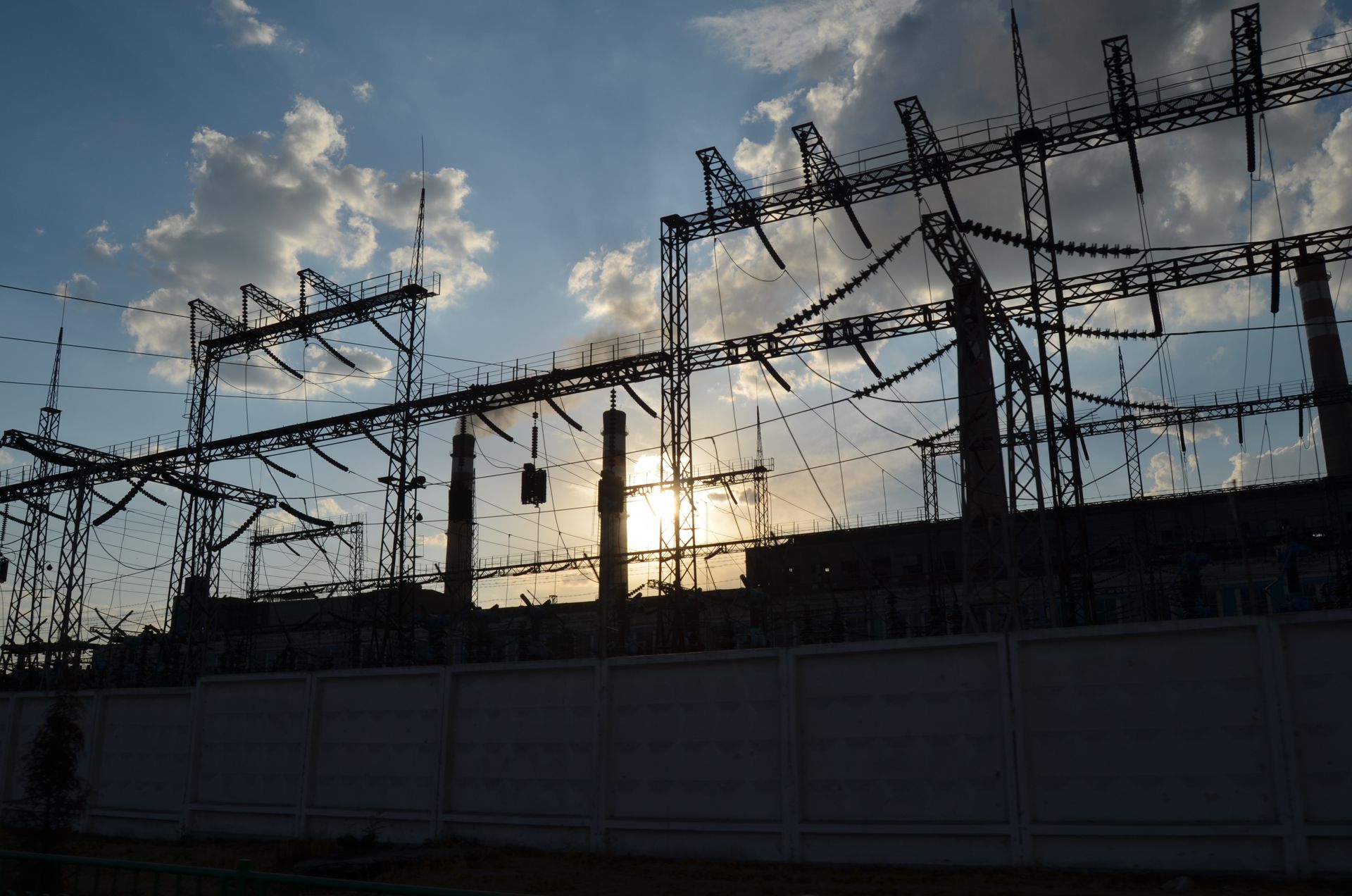 Uma usina elétrica com o sol brilhando através das nuvens