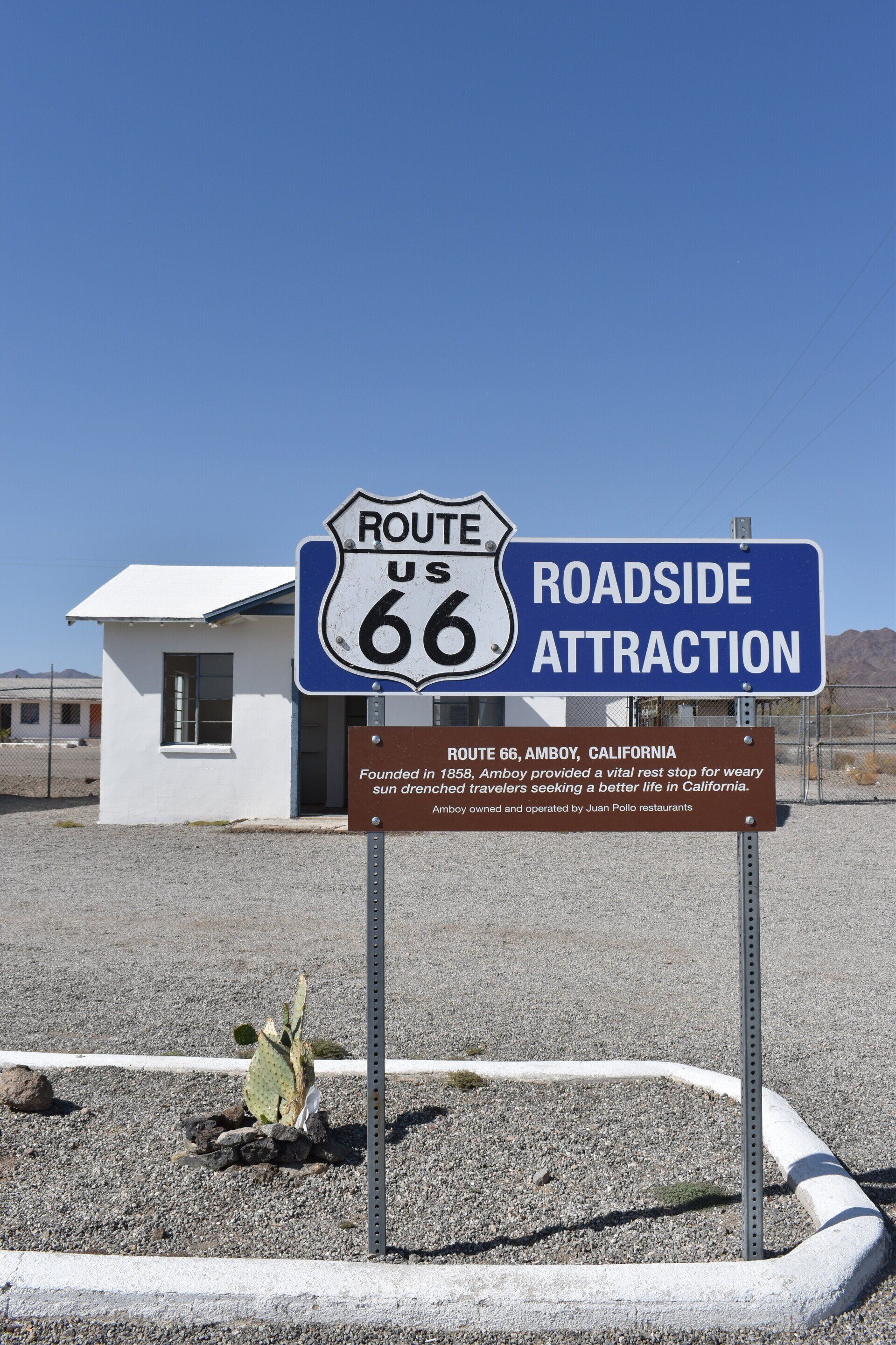 A blue sign for route 66 roadside attraction