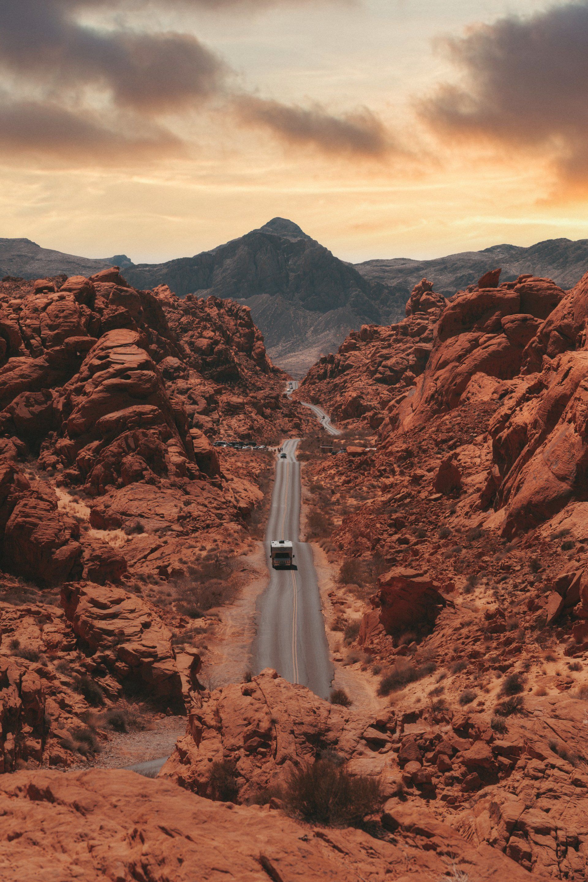 a car is driving down a road in the middle of a desert .