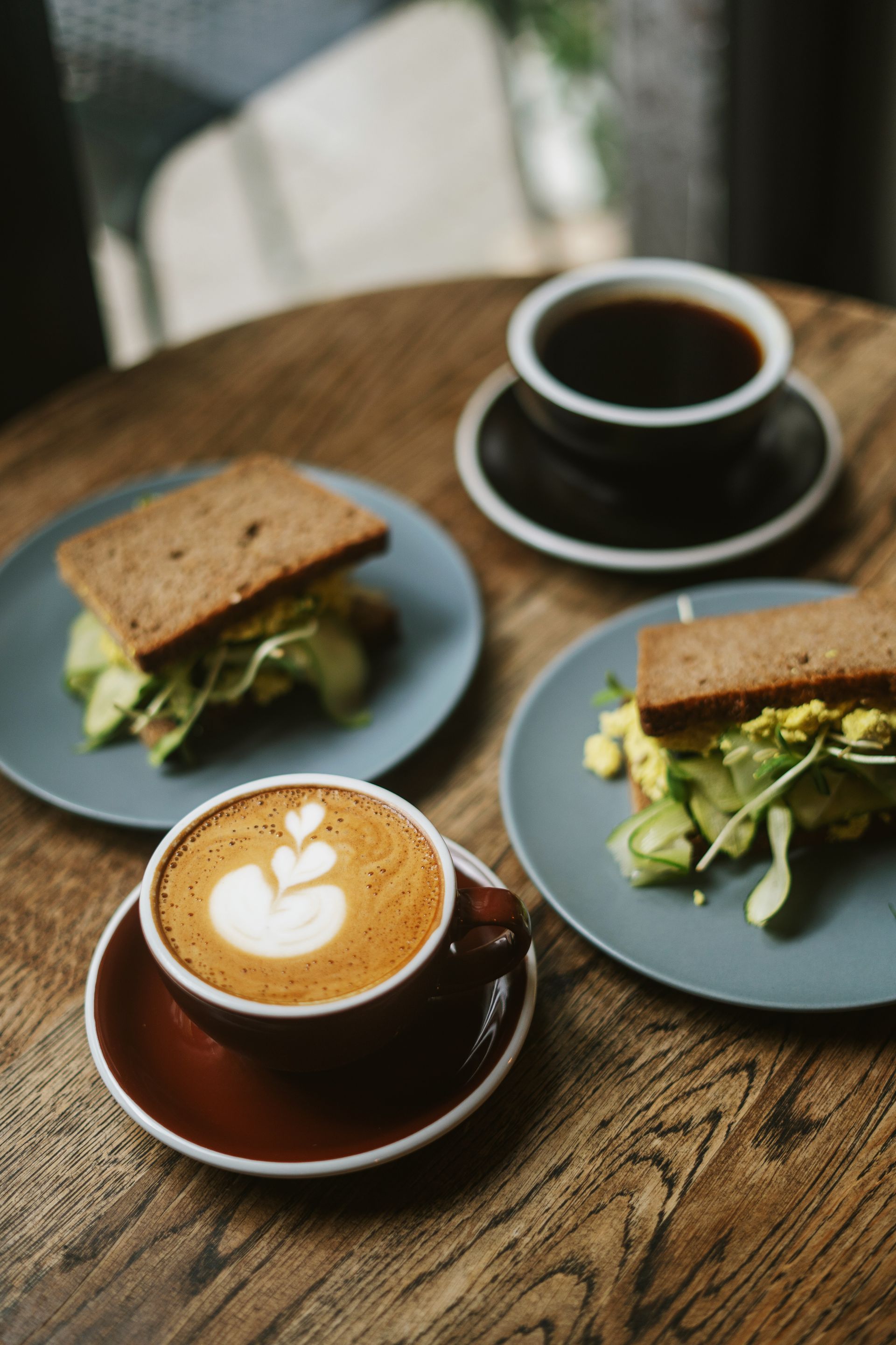 Latte art and black coffee with avocado sandwiches at a cafe