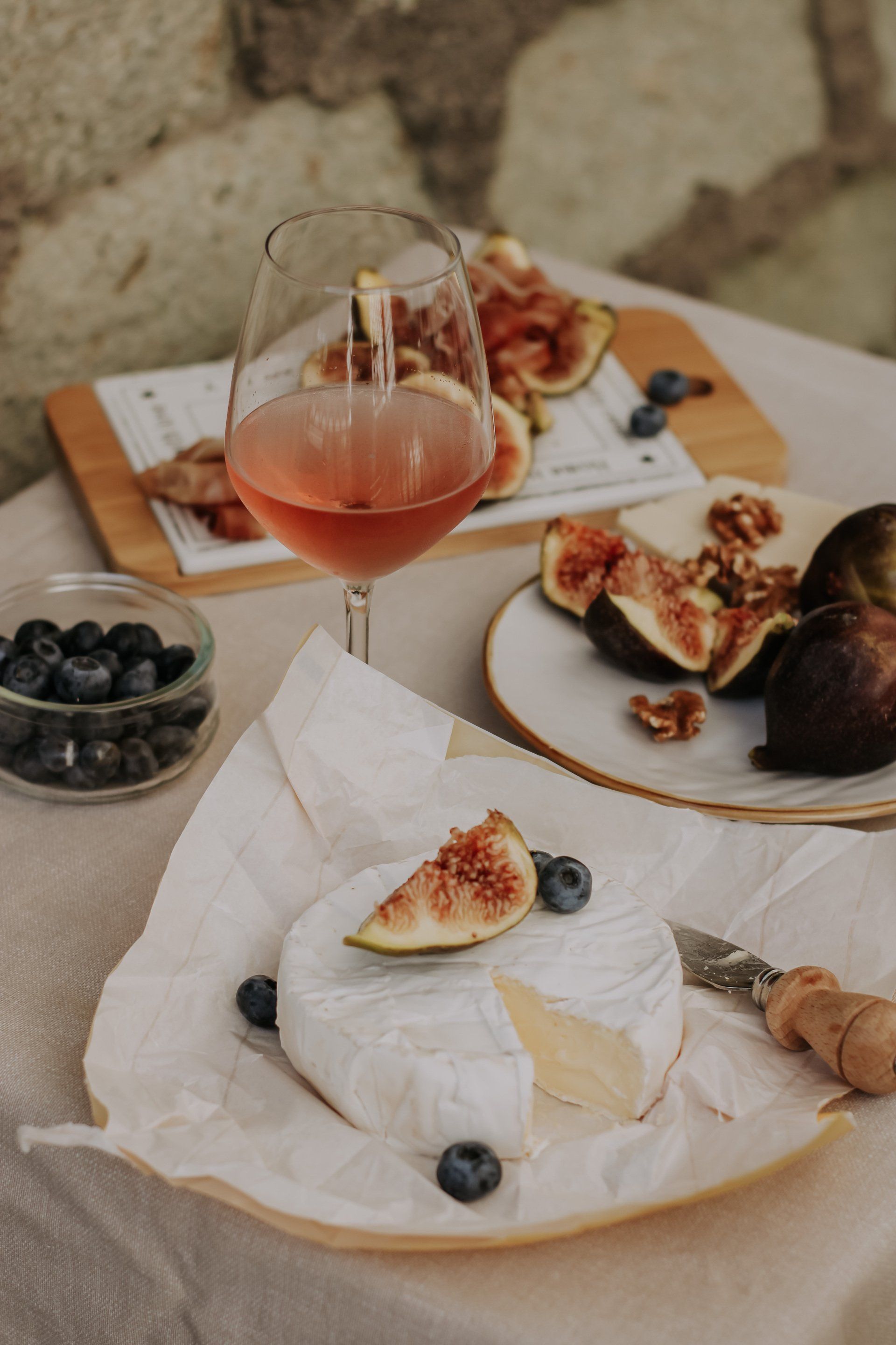 Rose wine and cheese board with figs and blueberries.