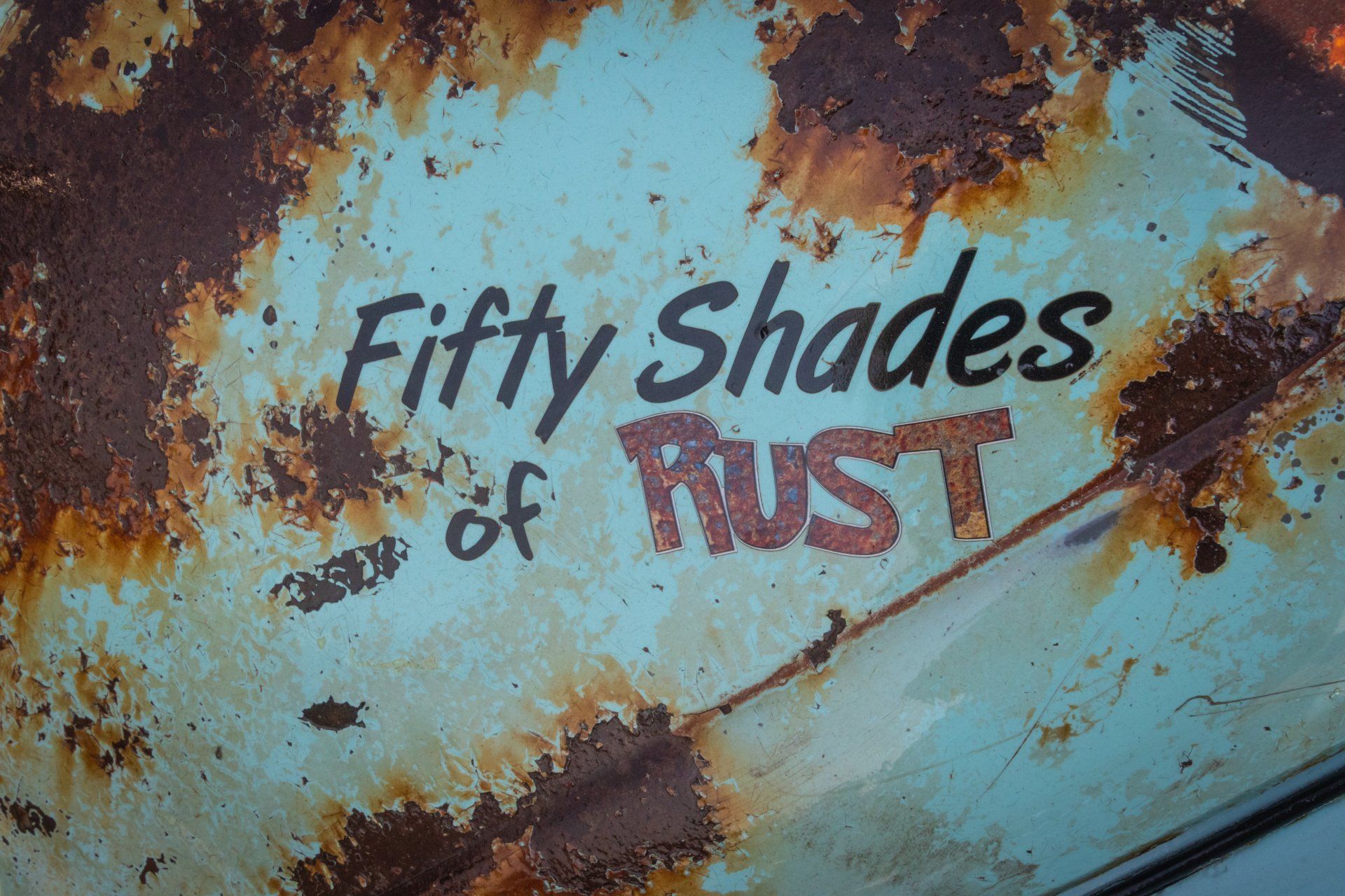 tidigare lackad yta med texten 'Fifty Shades of RUST' som delvis har rostat
