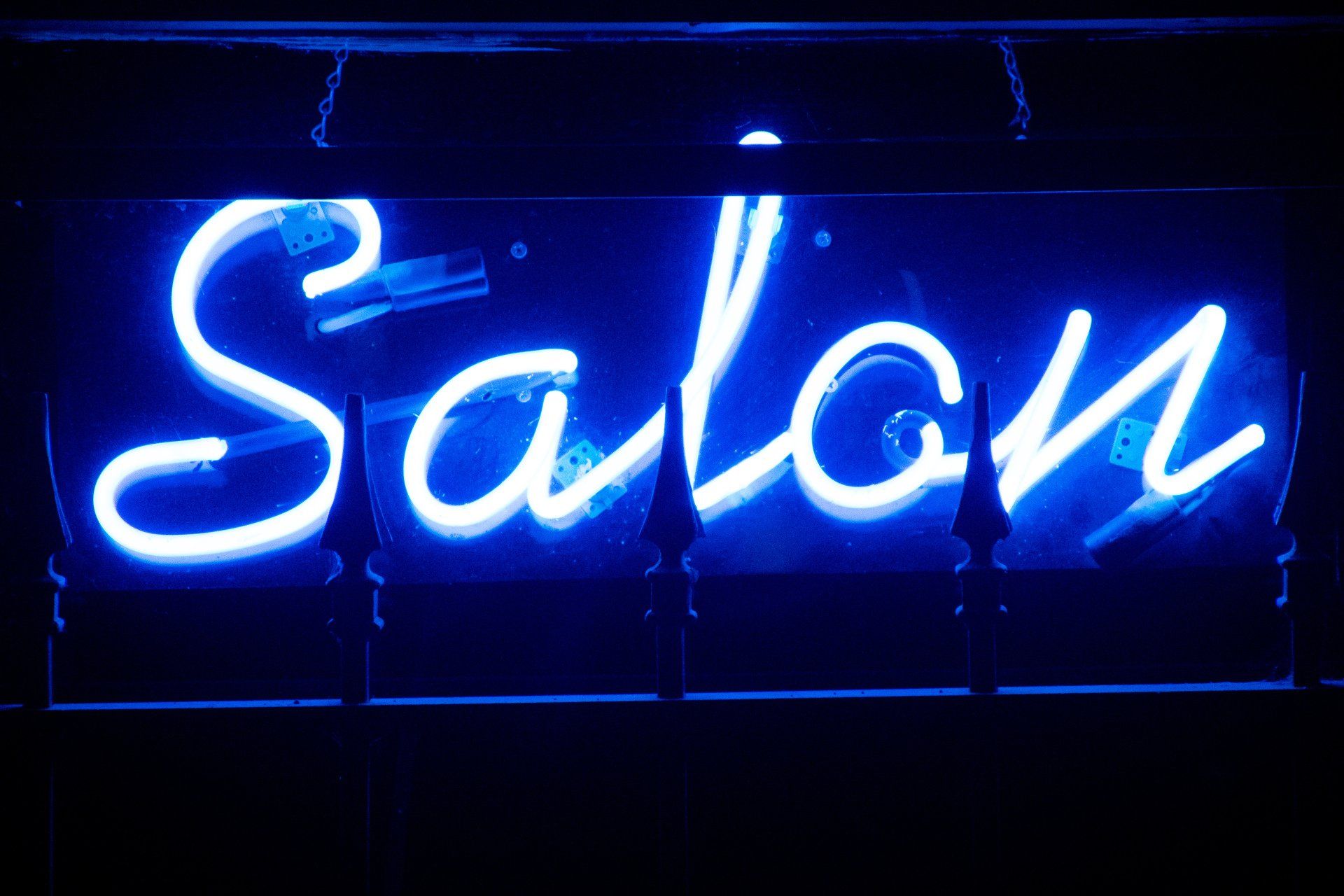 A neon sign that says salon is lit up in blue