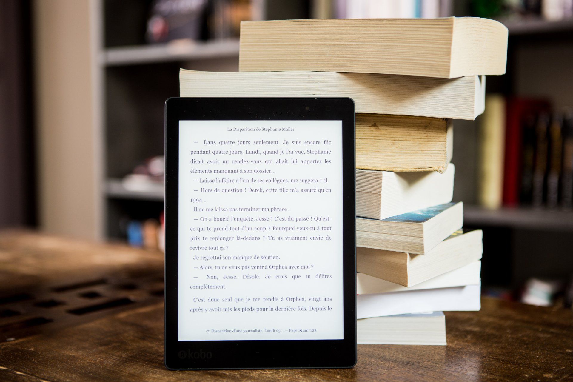 A tablet is sitting on top of a stack of books.