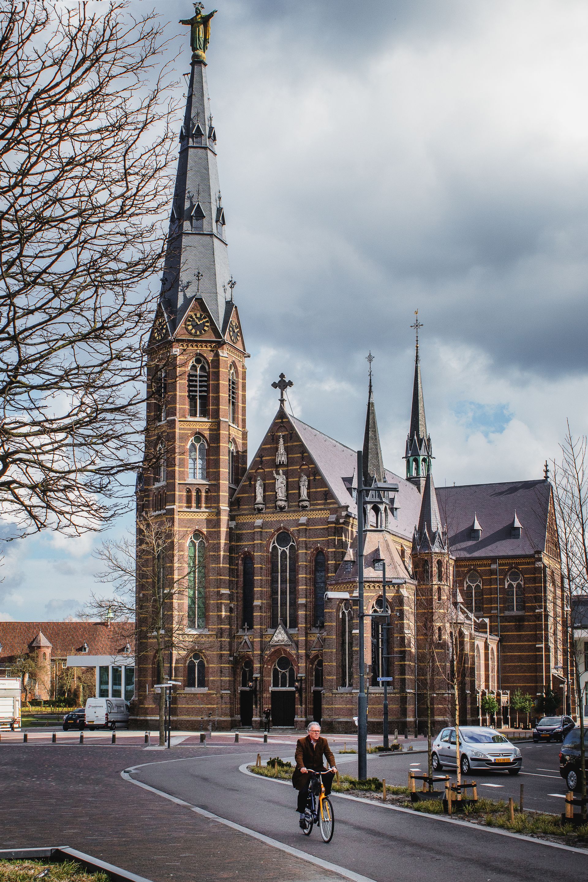 Een man fietst voor een grote kerk.