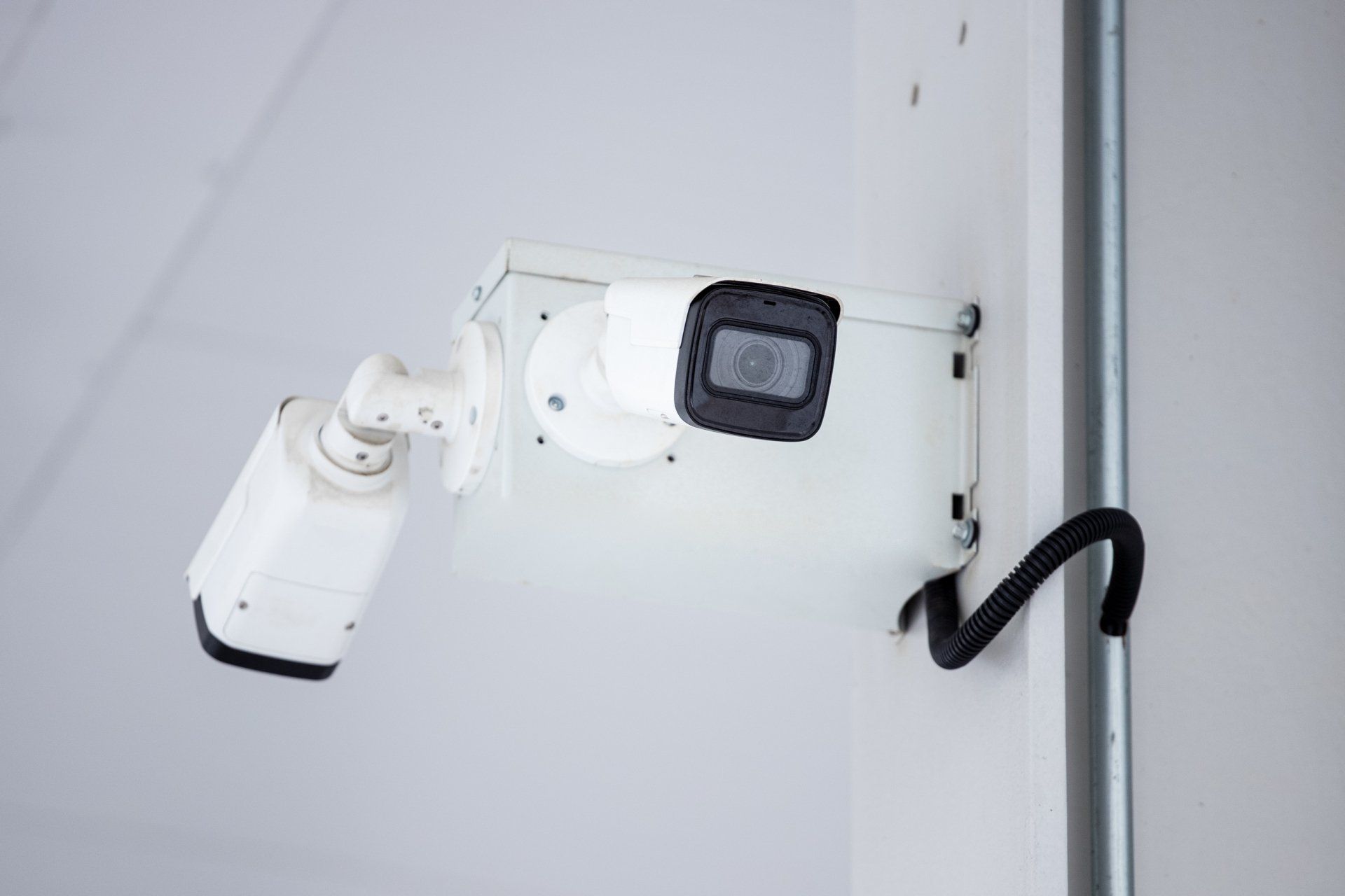 A security camera is mounted on the wall of a building.