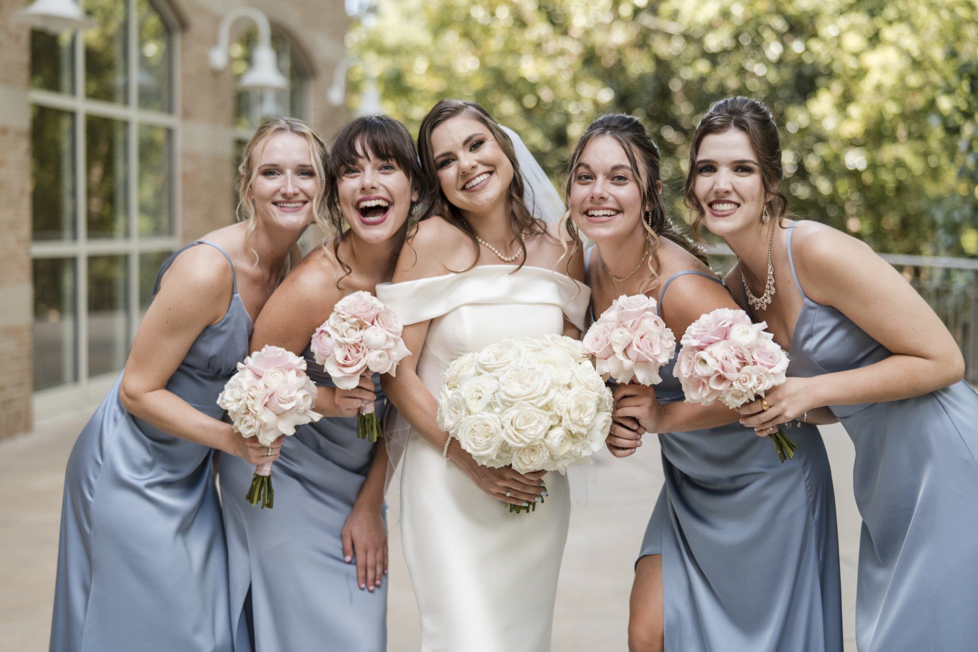 A bride and her bridesmaids are posing for a picture.