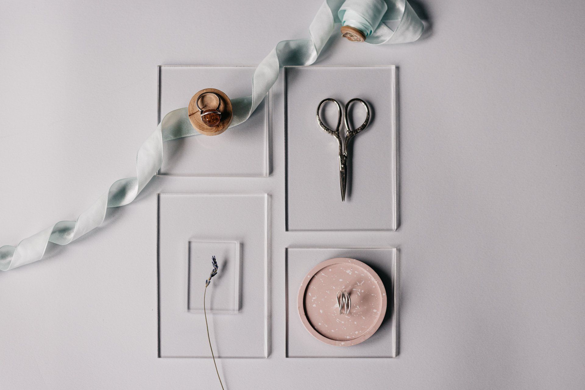 A pair of scissors , a button , and a ribbon are sitting on a table.