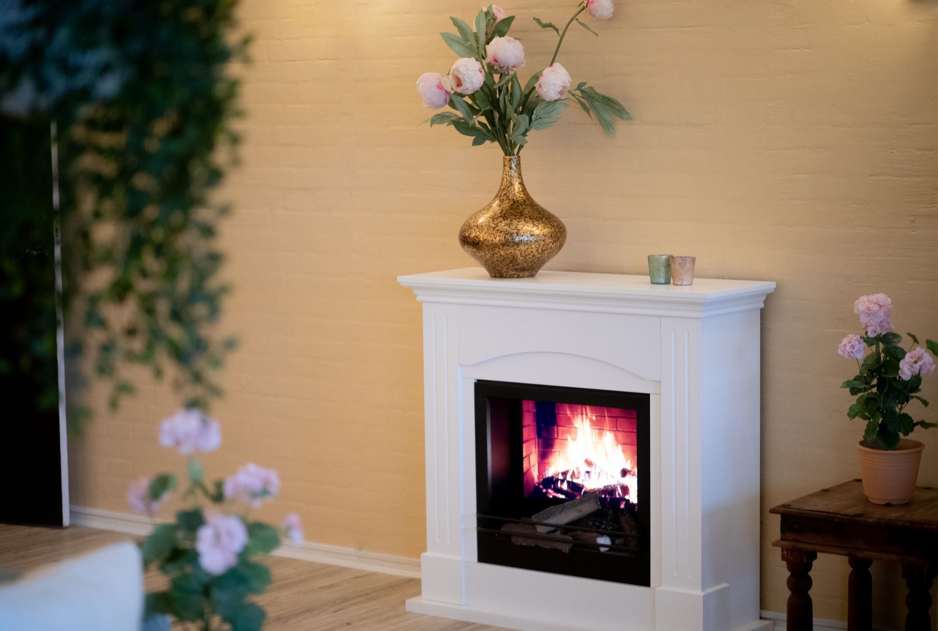 a fireplace with a vase of flowers on top of it