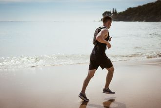 Ein Mann läuft am Strand in der Nähe des Ozeans.