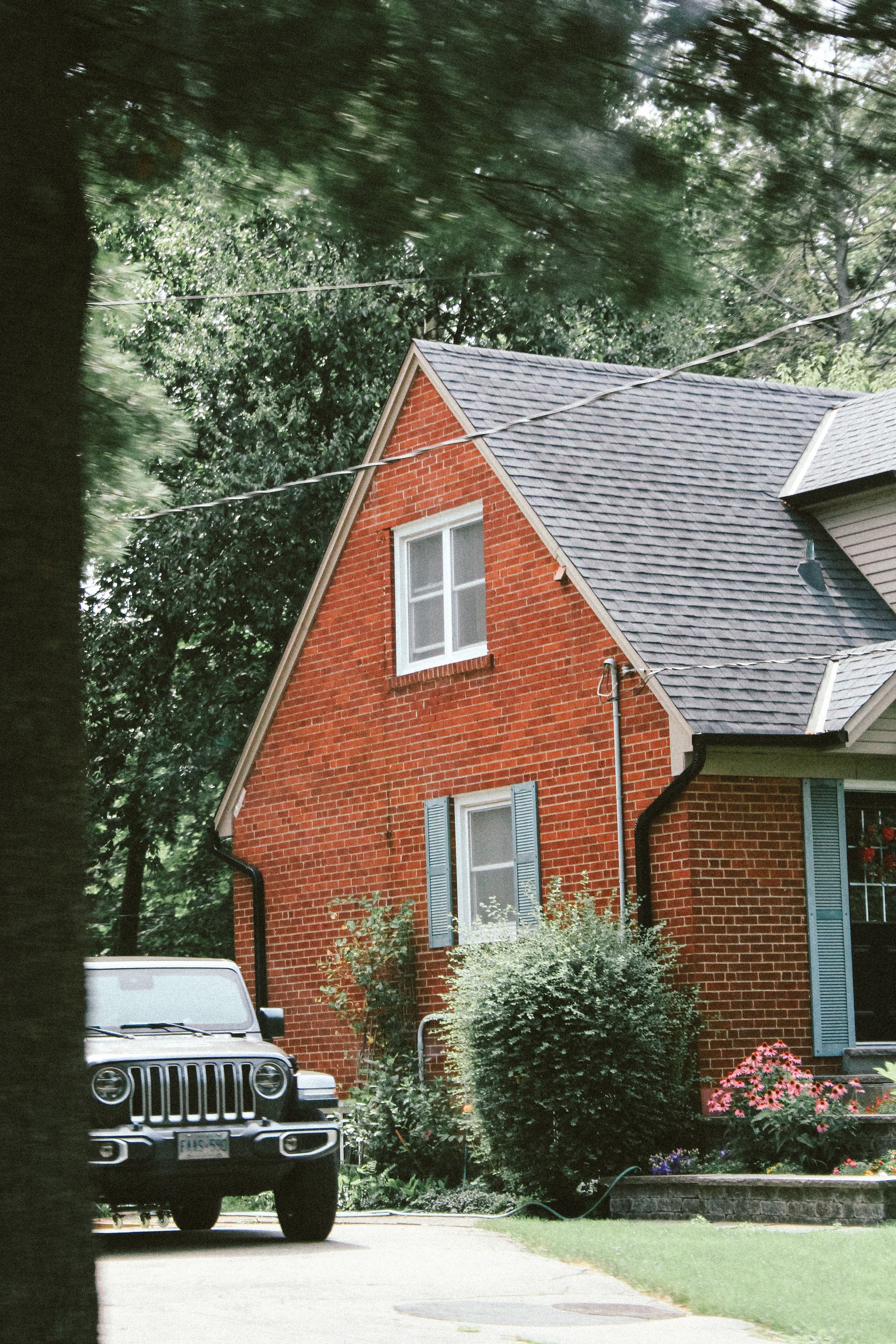 a house shingle and a vehicle in front