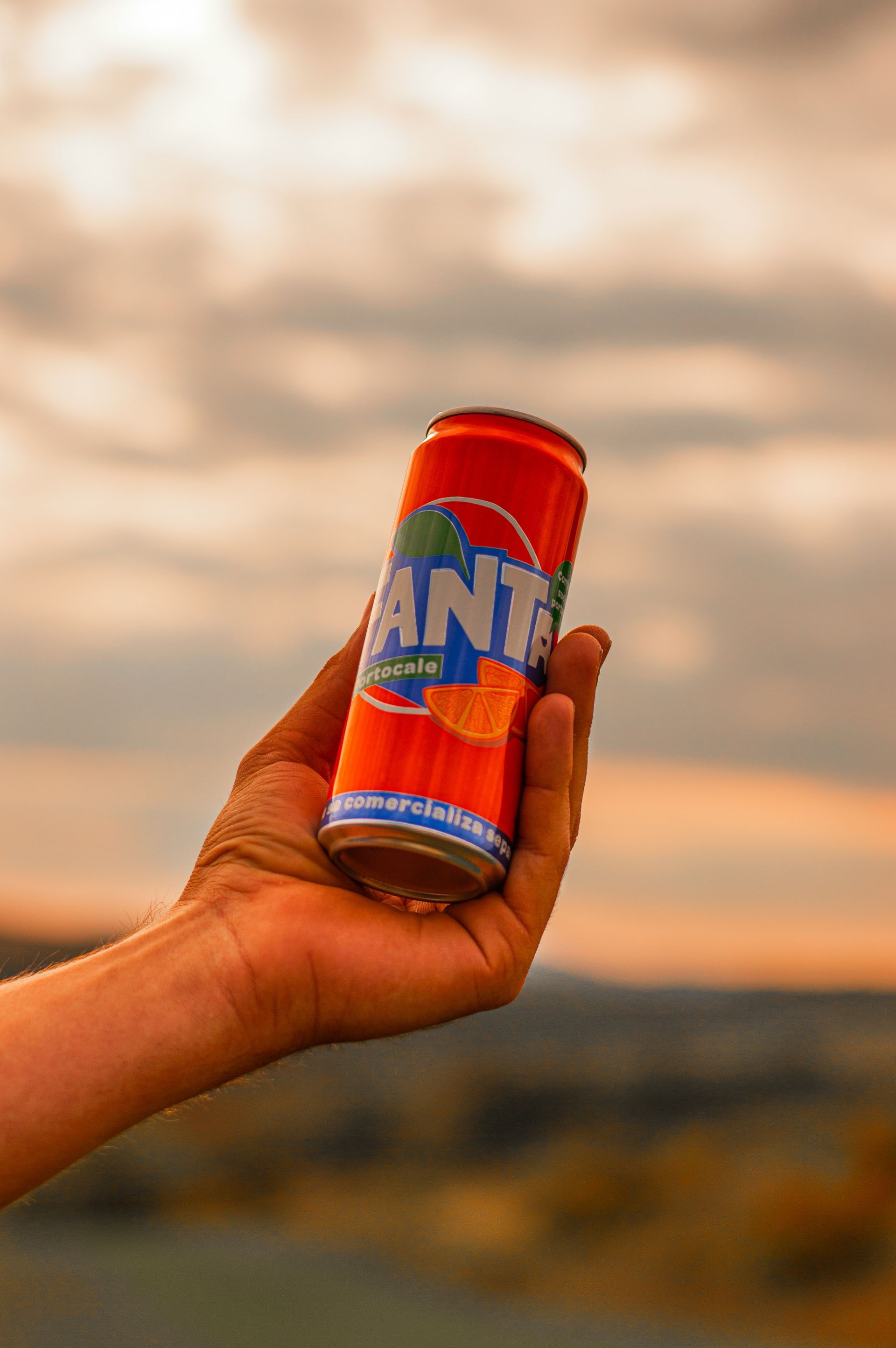 A person is holding a can of fanta in their hand.