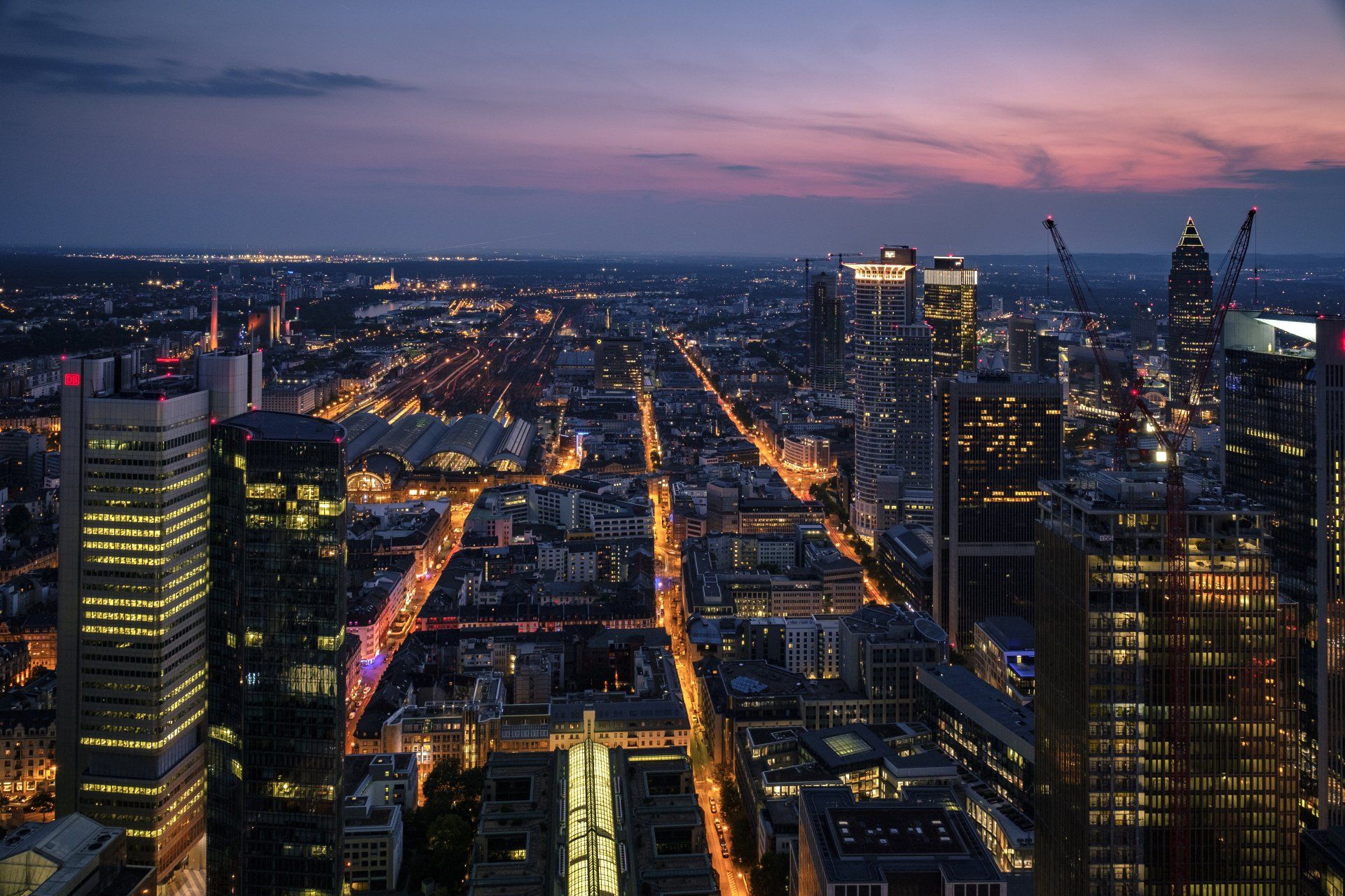 an aerial view of a city at night with lots of tall buildings