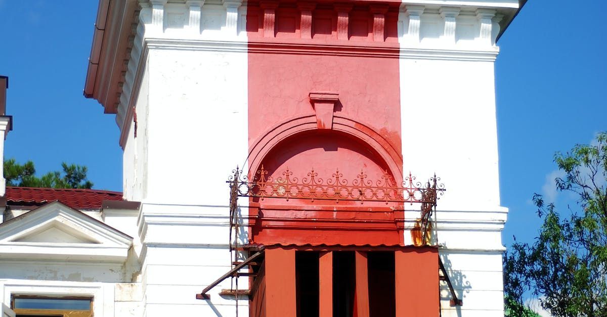 A red and white building with a balcony on the side