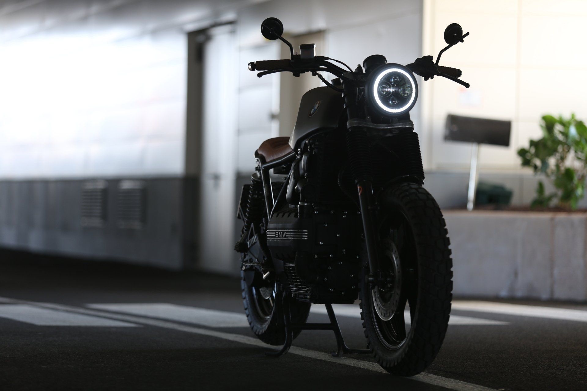 A black motorcycle is parked in a dark parking garage.