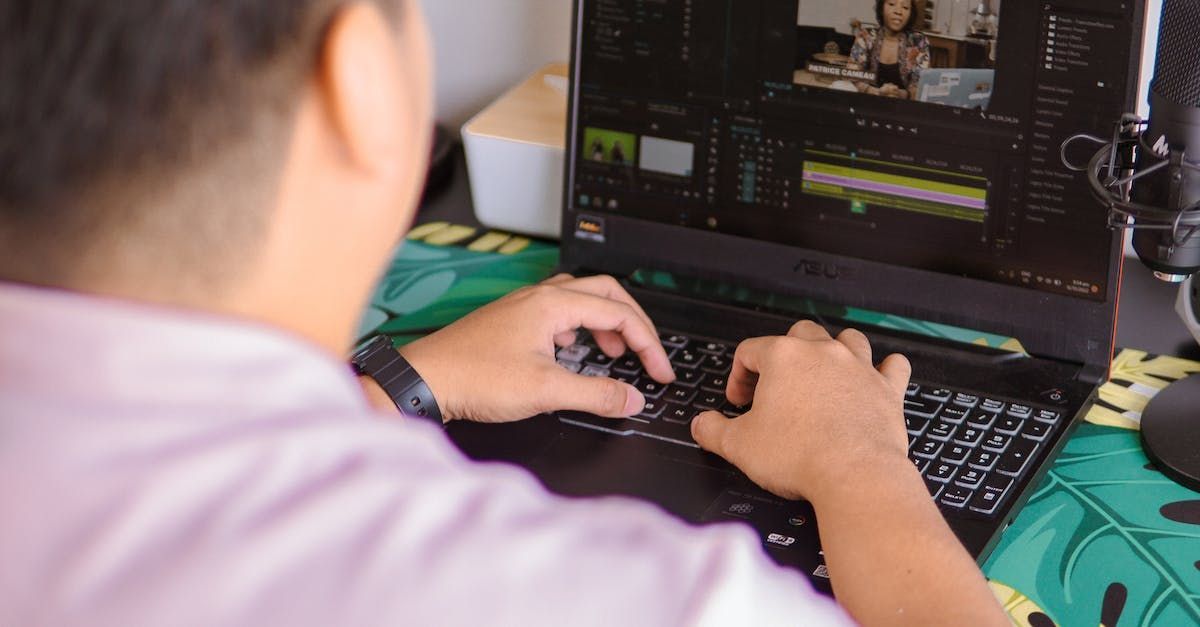 A man is typing on a laptop computer.