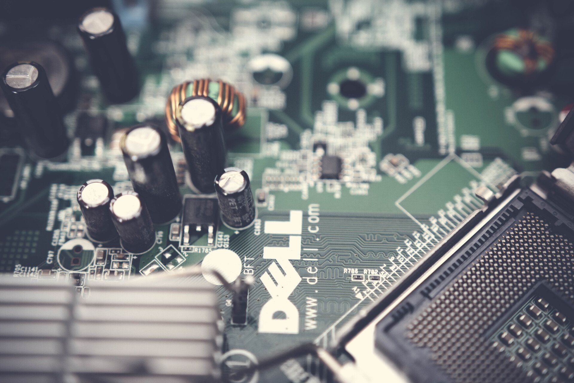 A close up of a dell computer motherboard with a lot of electronic components on it.