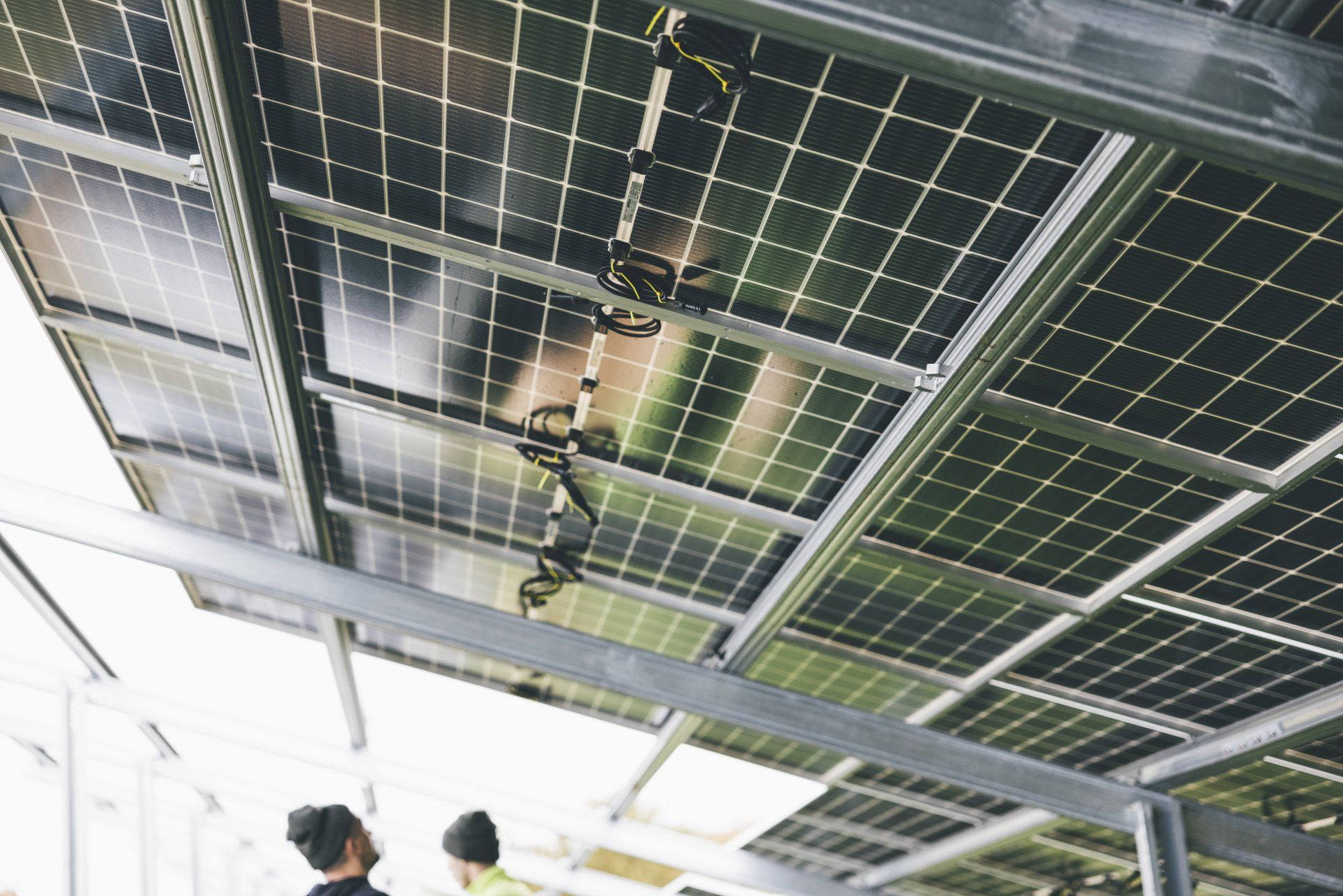 A group of people are standing under a roof with solar panels.