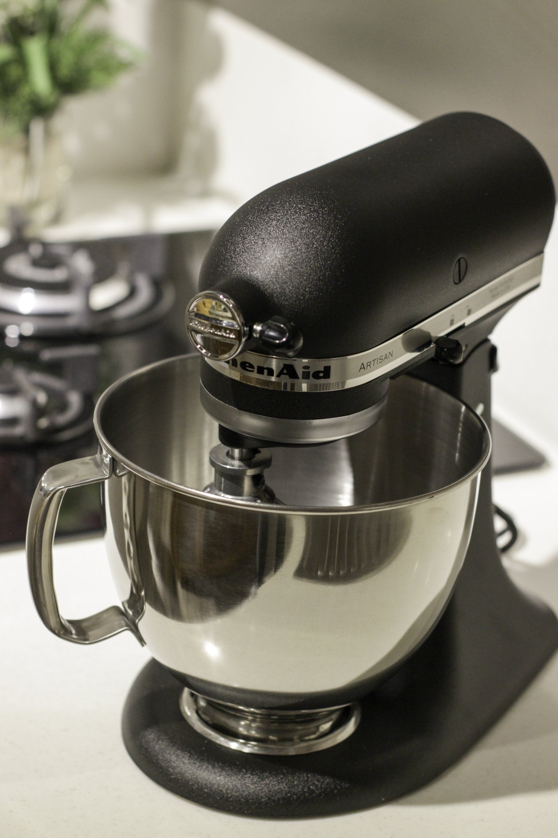 An elegant silver KitchenAid stand mixer sits on a kitchen countertop,