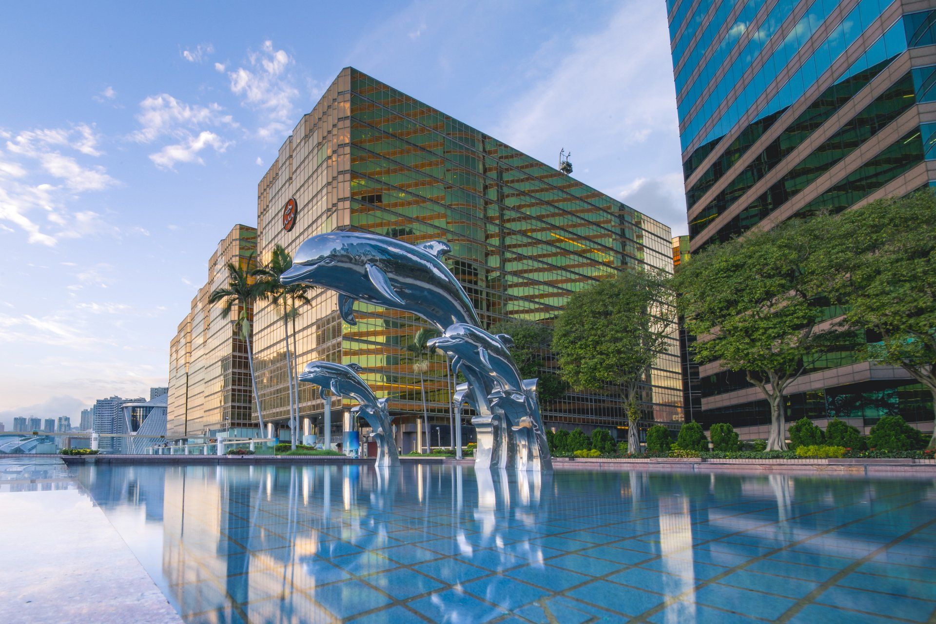 A fountain with dolphins jumping out of it in front of a building.