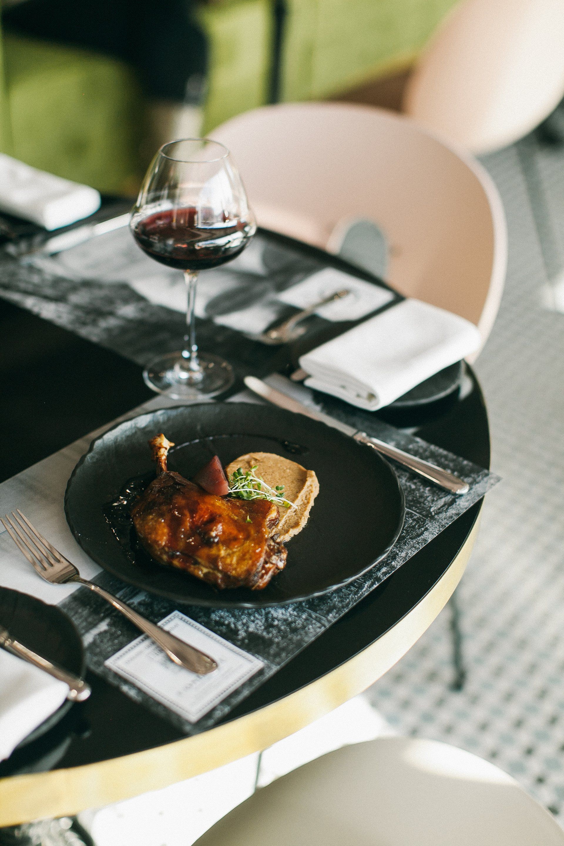 Um prato de comida e uma taça de vinho sobre a mesa.