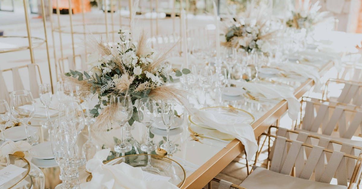A long table with lots of glasses and flowers on it.