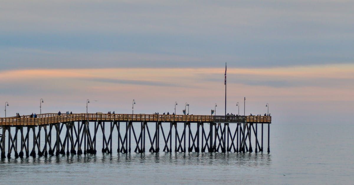 Wooden pier extending into calm water, under a muted sky at dusk.