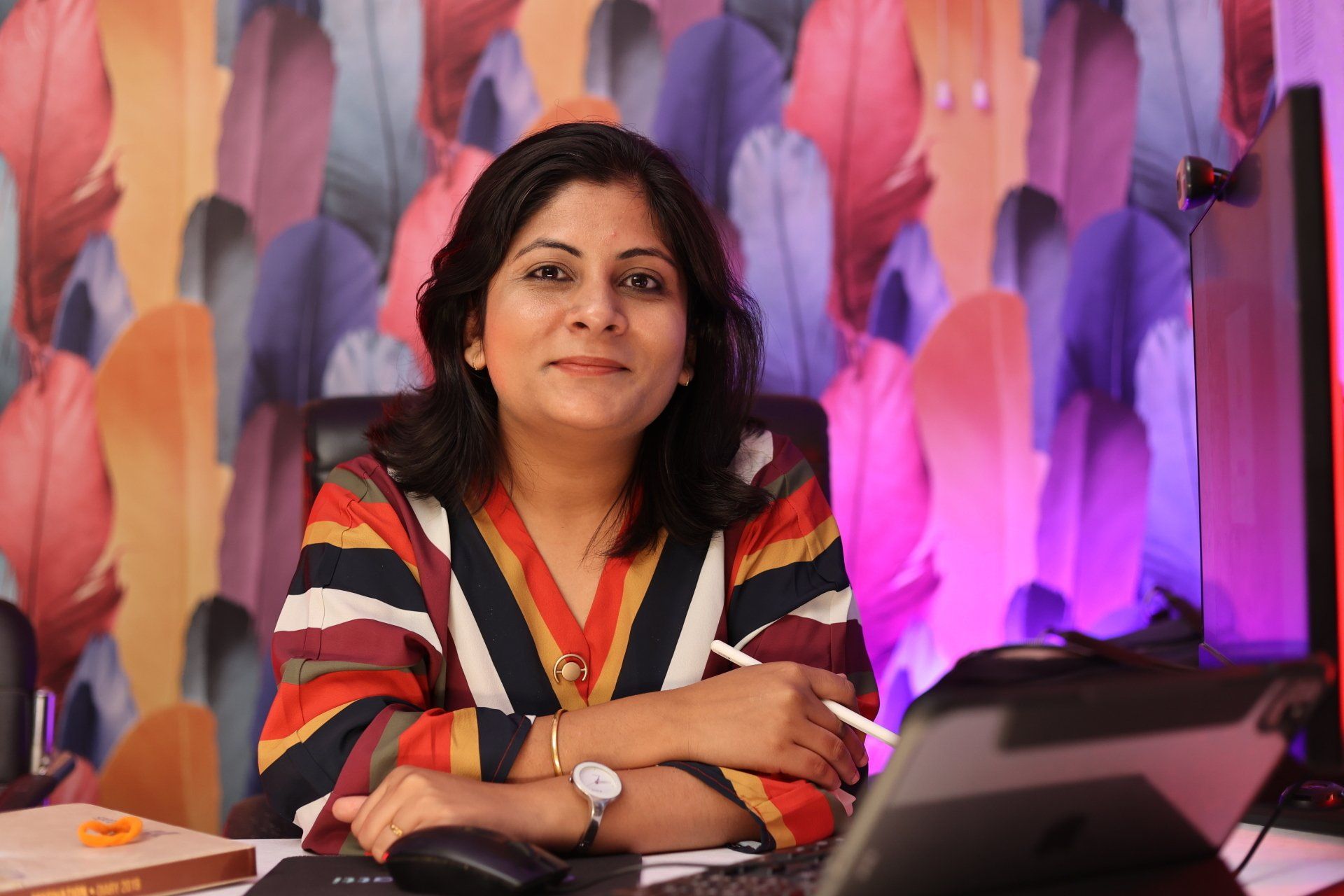 A woman is sitting at a desk in front of a computer.
