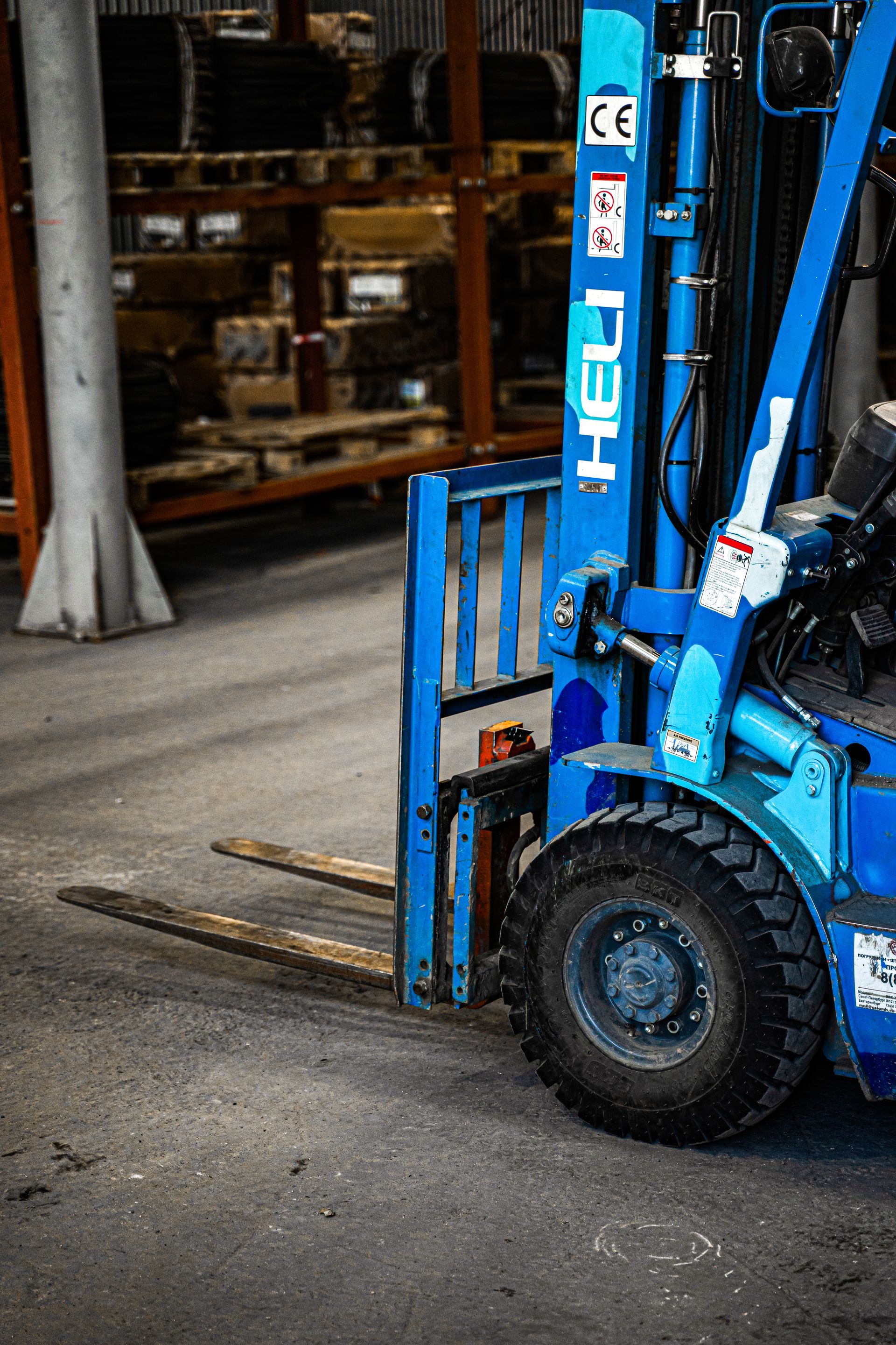 A blue forklift is parked in a warehouse.