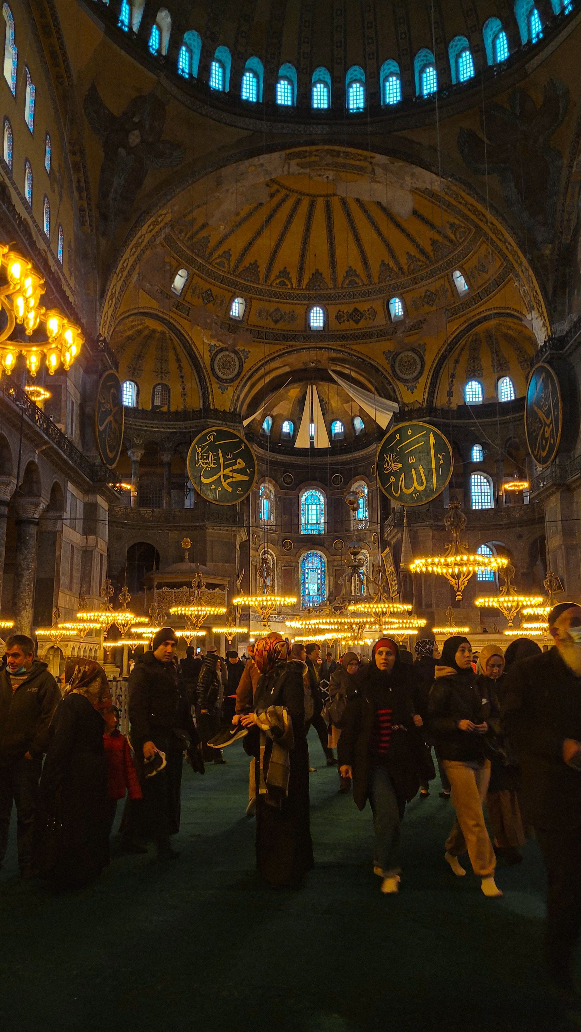 A group of people are walking through a very large building.