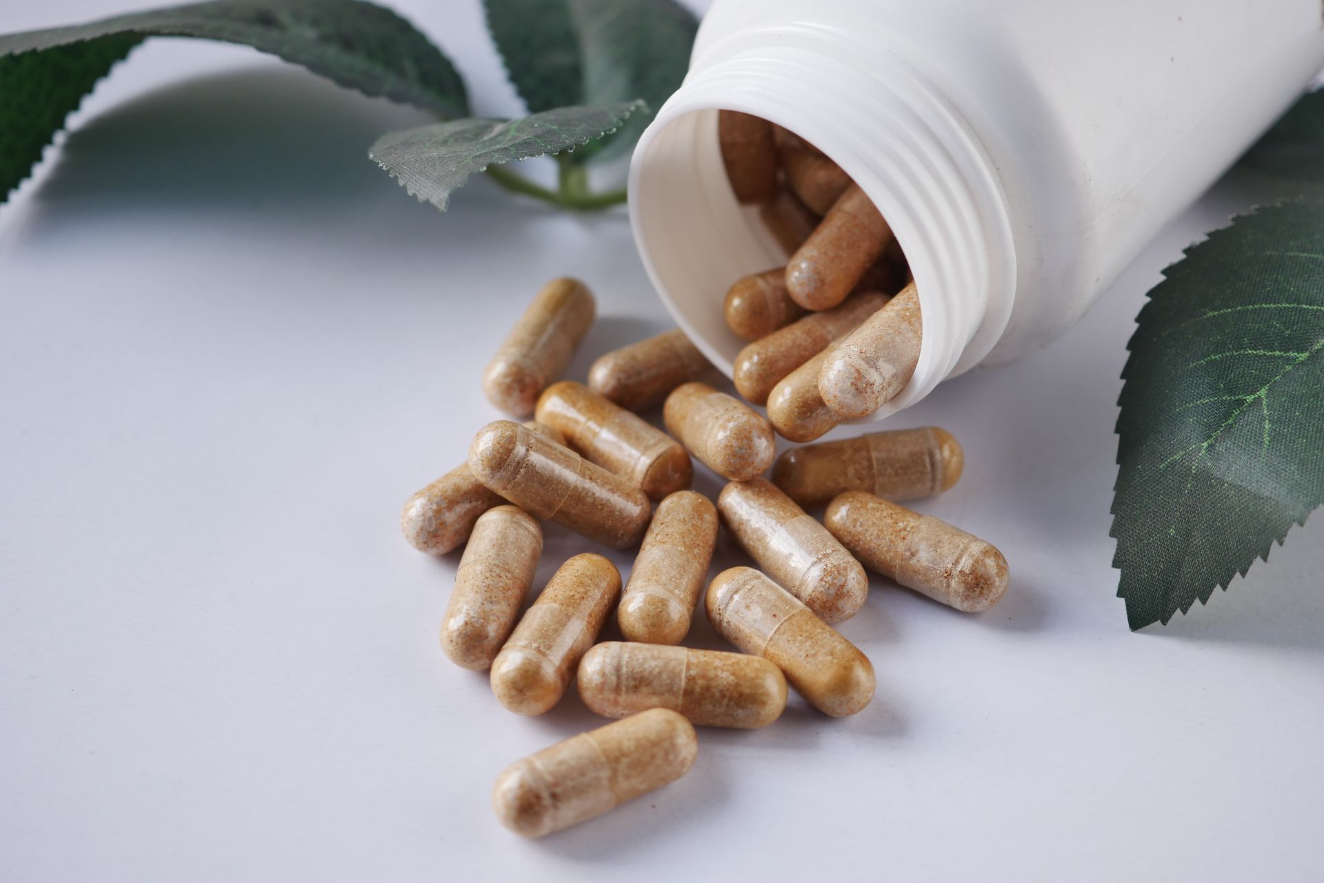 A bottle of pills is pouring out of it on a table.