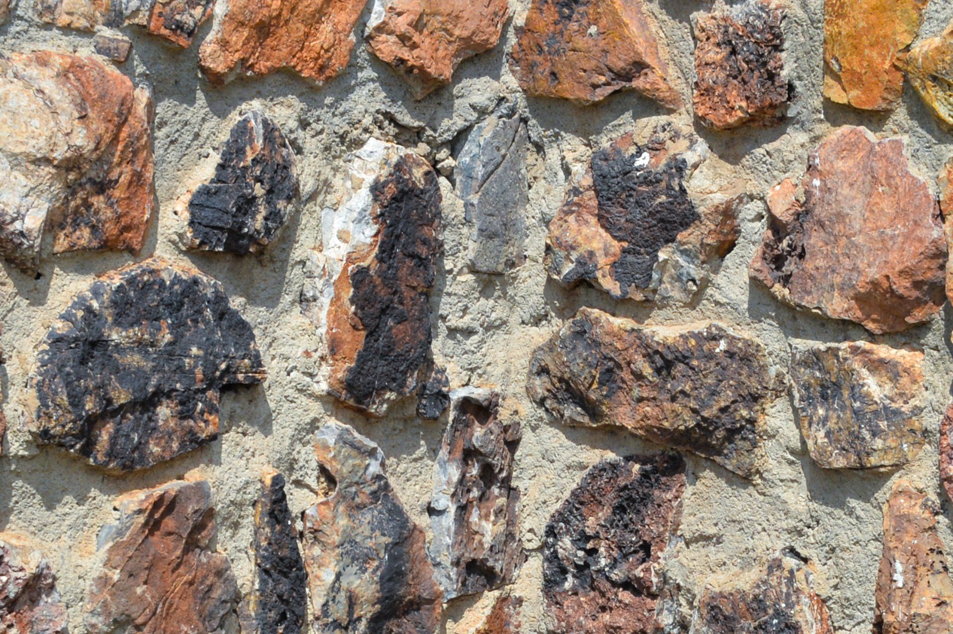 A close up of a stone wall with a lot of rocks. Old stone foundations that can be damp-proofed and repaired.