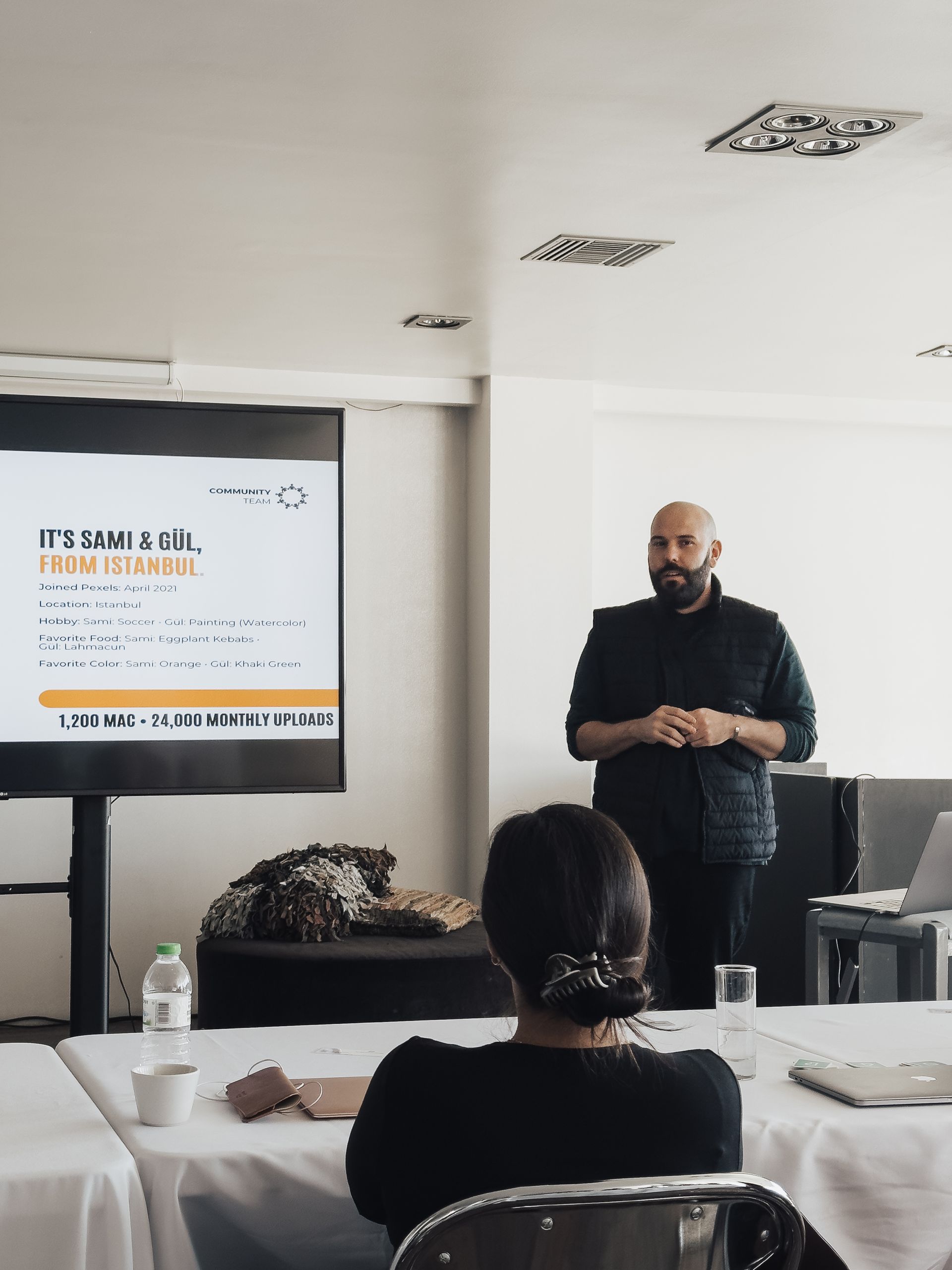 Man giving a presentation with a slideshow, facing an audience.