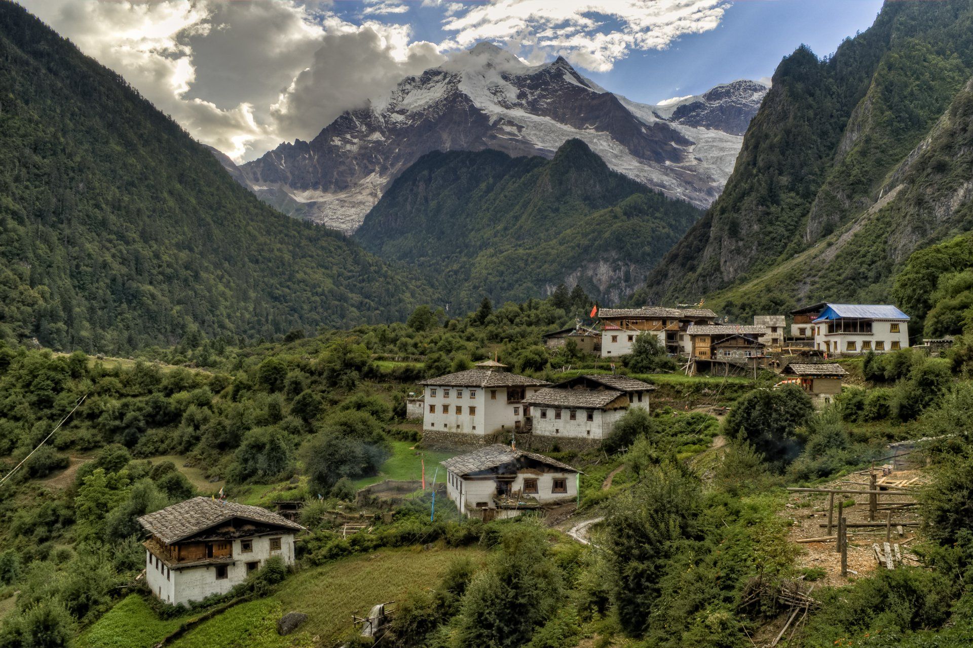 A small village in the middle of a valley with mountains in the background