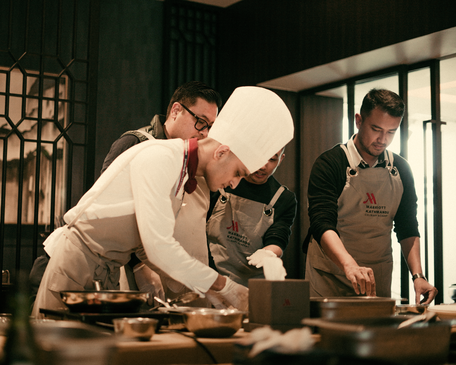 A group of chefs are preparing food in a kitchen.
