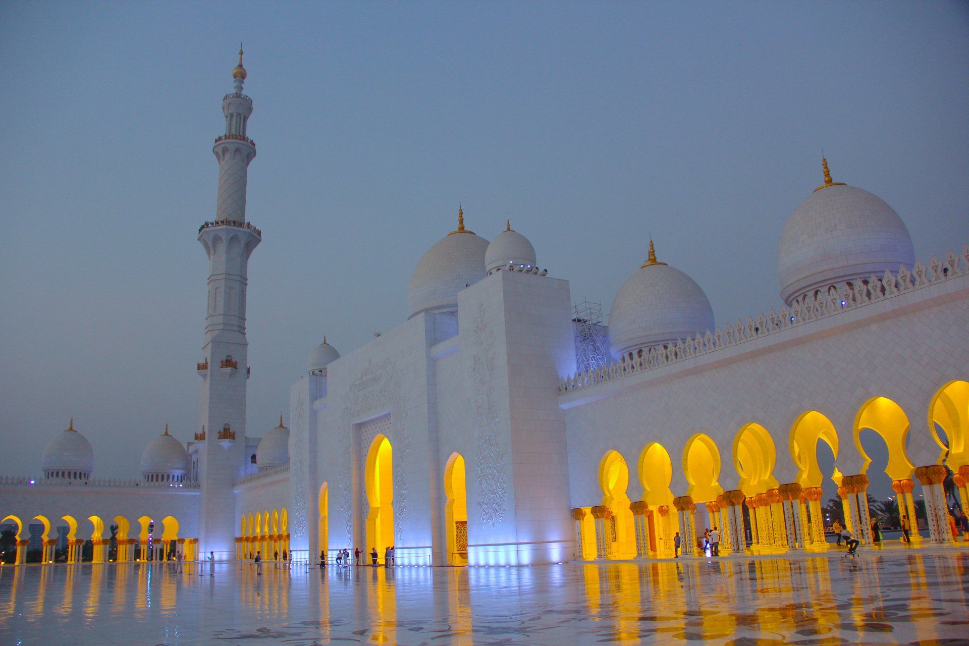 A large white mosque with a blue sky in the background.