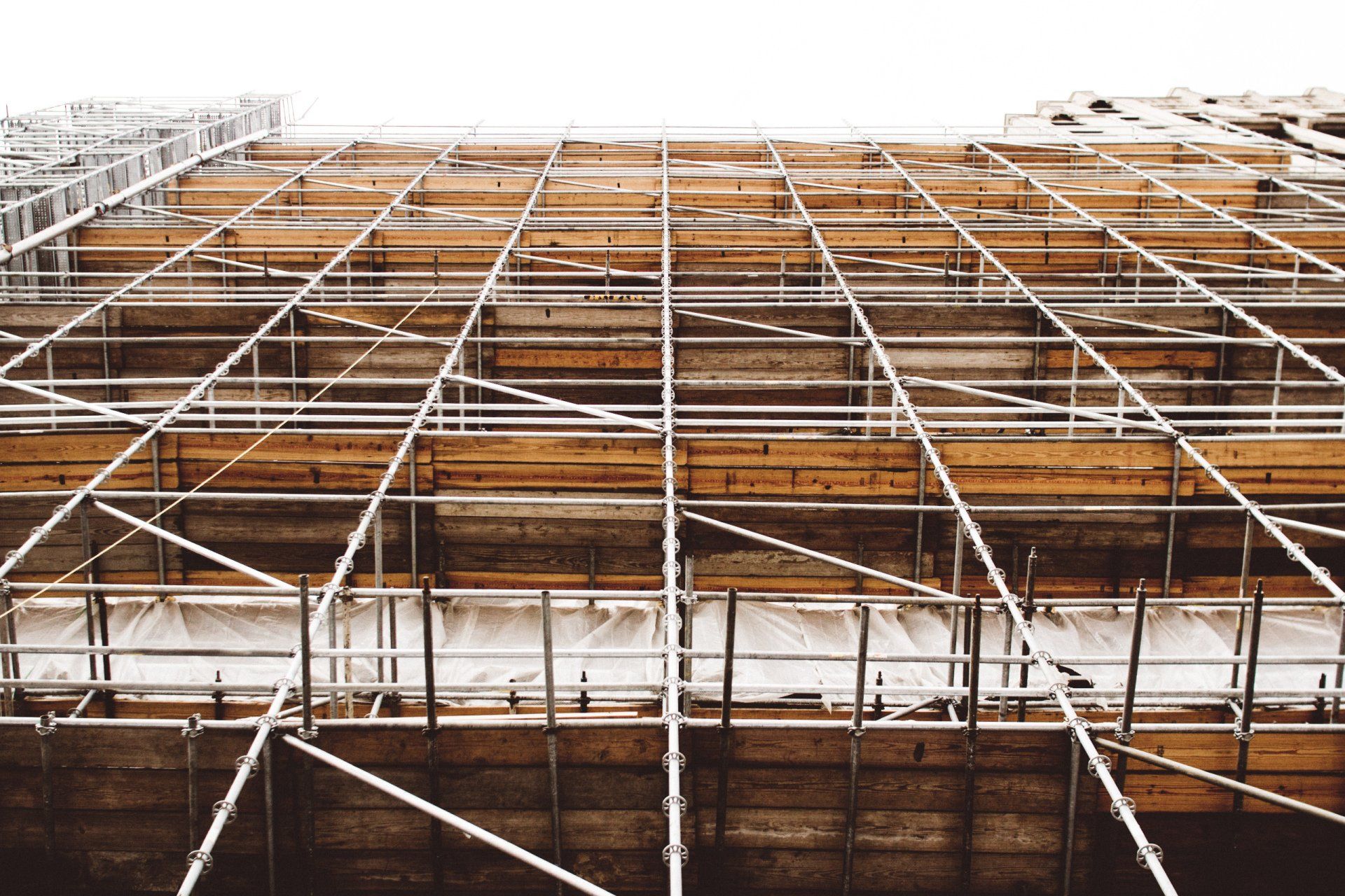 Scaffolding and formwork installed on a multi-story building exterior during concrete construction work