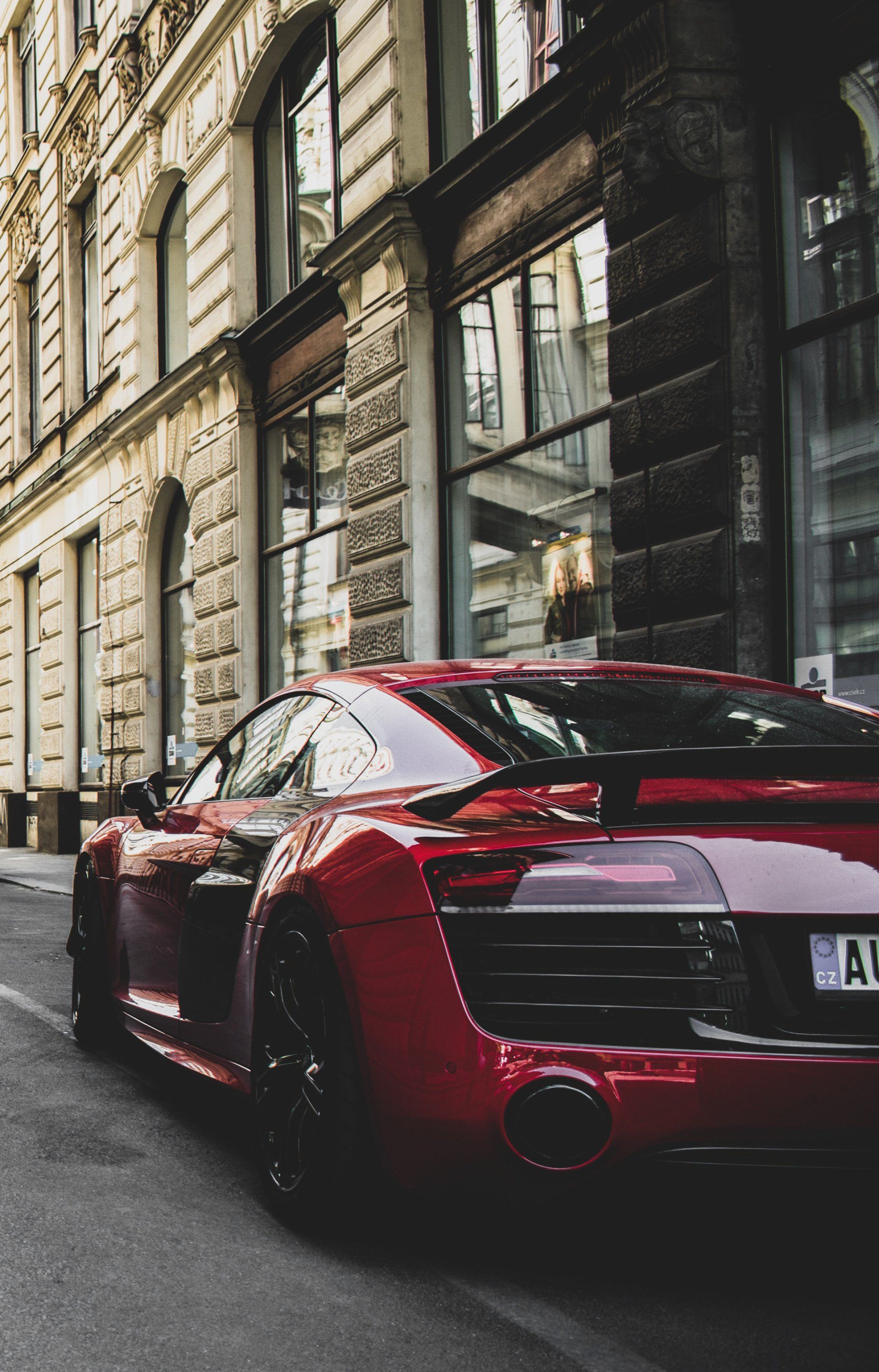 A red sports car is parked in front of a building.