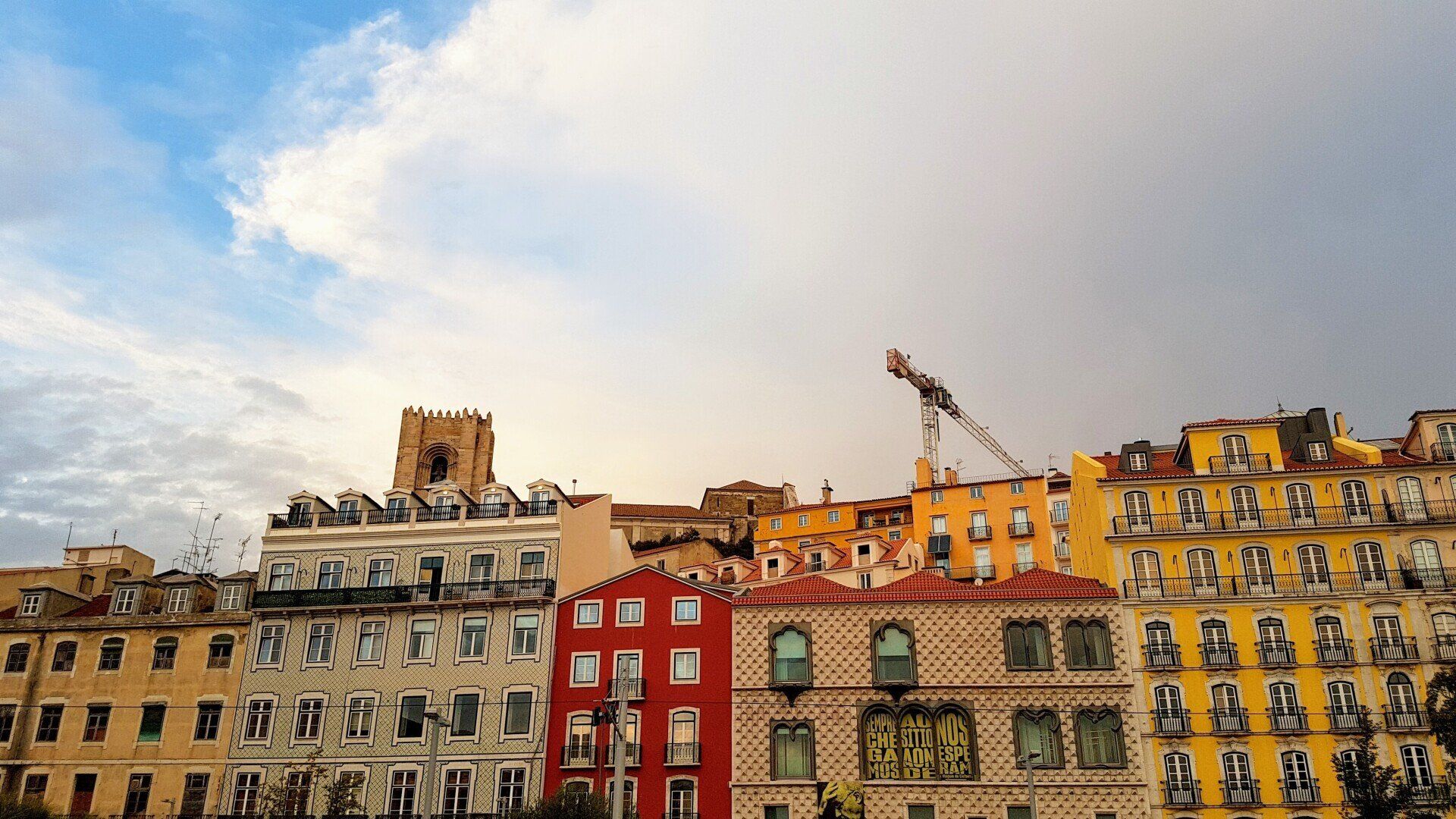 Uma fileira de edifícios com um céu azul ao fundo.